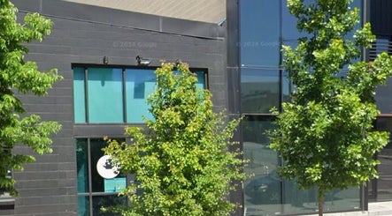 Front view of TEAspot: Denver at Denver, Colorado, US, with modern architecture and green trees.