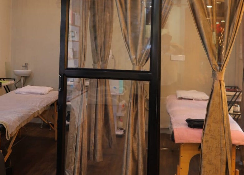 Private treatment rooms at Naturā Unisex Salon, Pune, Maharashtra, IN, with elegant curtains and massage beds.