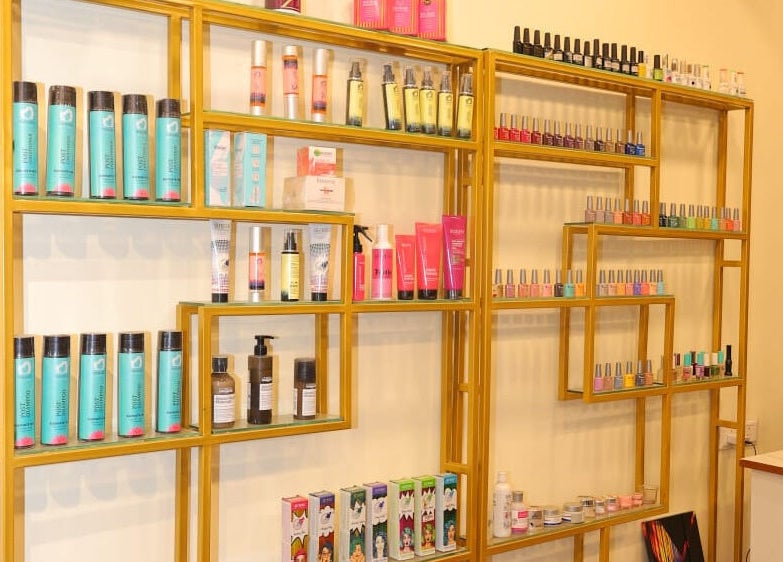 Product display shelves at Naturā Unisex Salon in Pune, Maharashtra, IN, featuring beauty products.