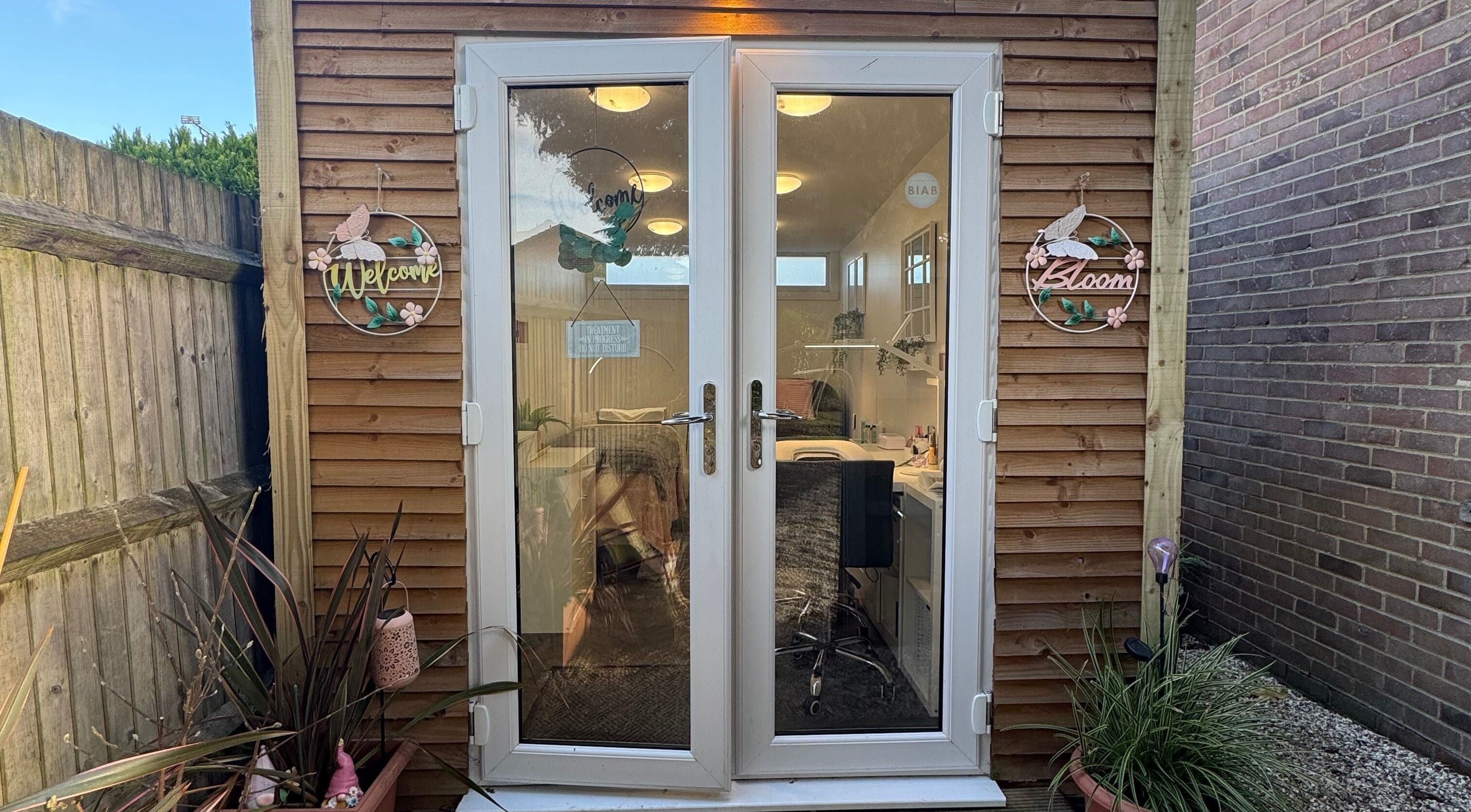 Inviting entrance of Utopia Beauty Farnham in Farnham, England, GB, with decorative signs and potted plants.