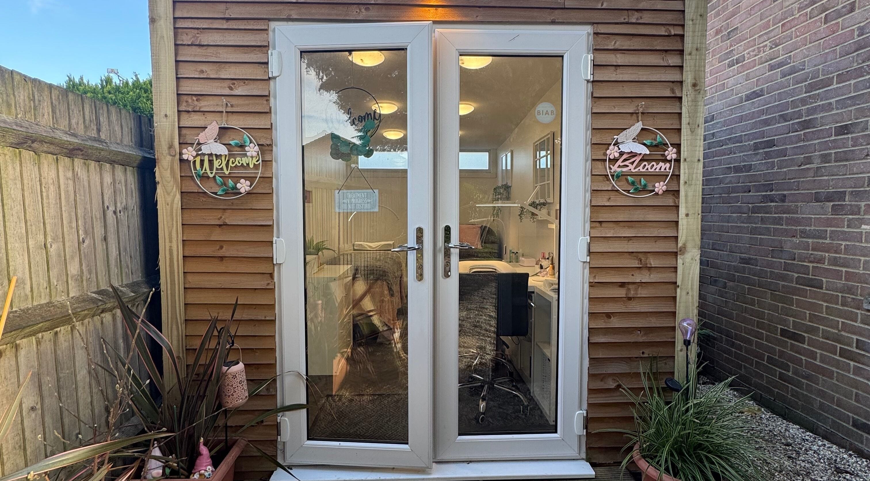 Inviting entrance of Utopia Beauty Farnham in Farnham, England, GB, with decorative signs and potted plants.
