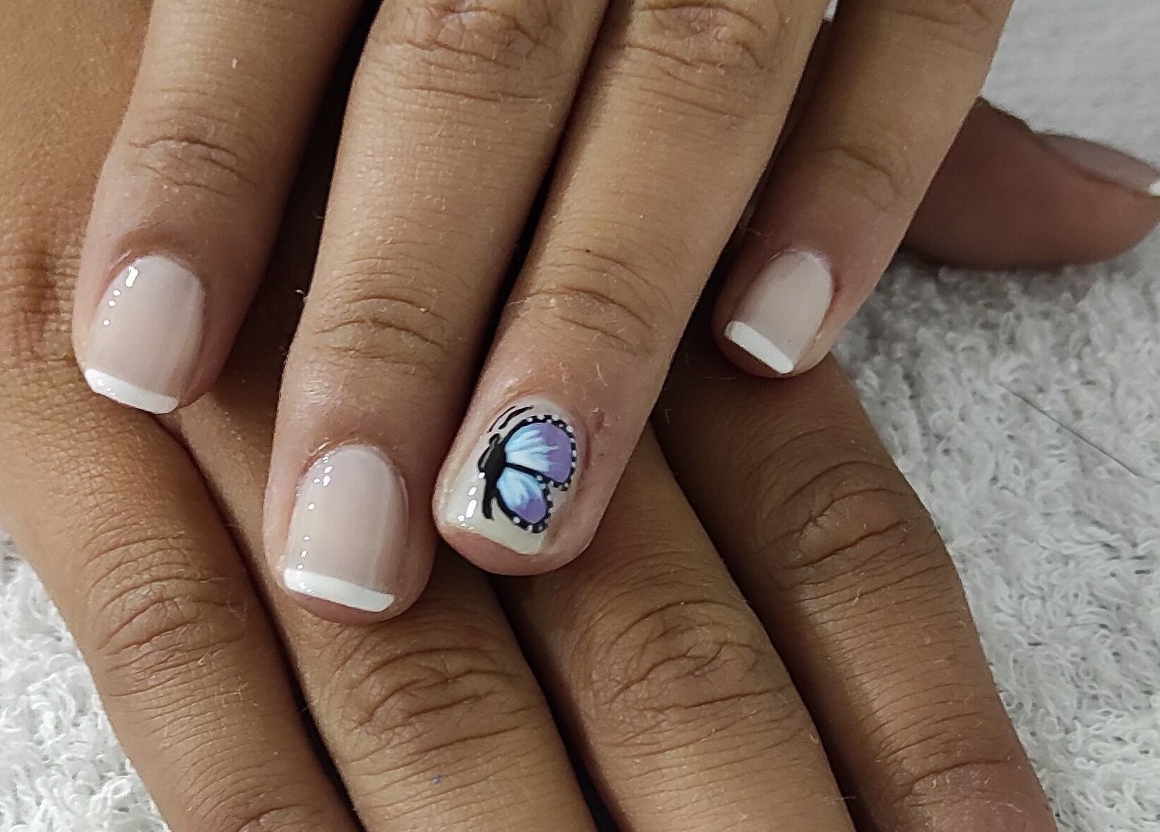Uñas decoradas con diseño de mariposa en Magi Cuts23, Bogotá, Bogotá, CO. Estilo único y delicado.