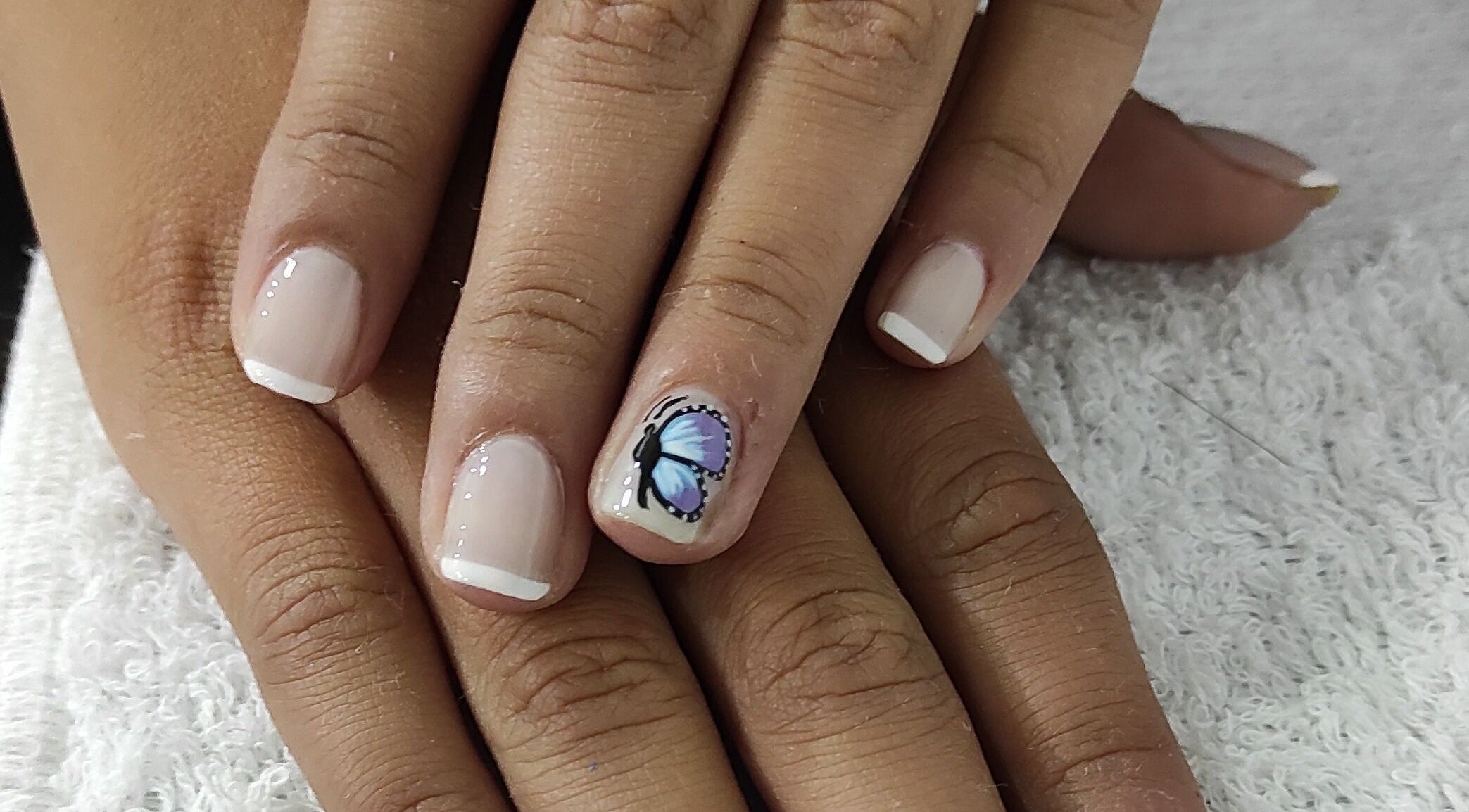 Uñas decoradas con diseño de mariposa en Magi Cuts23, Bogotá, Bogotá, CO. Estilo único y delicado.