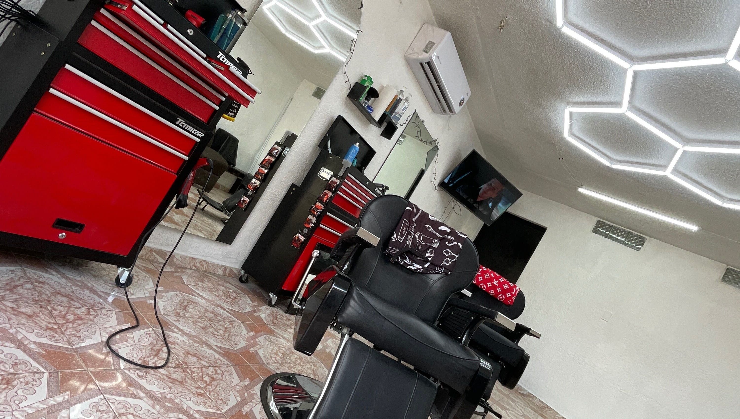 Interior de La Navaja Negra Barberia en Kanasín, Yucatán, MX. Silla negra y decoración moderna.