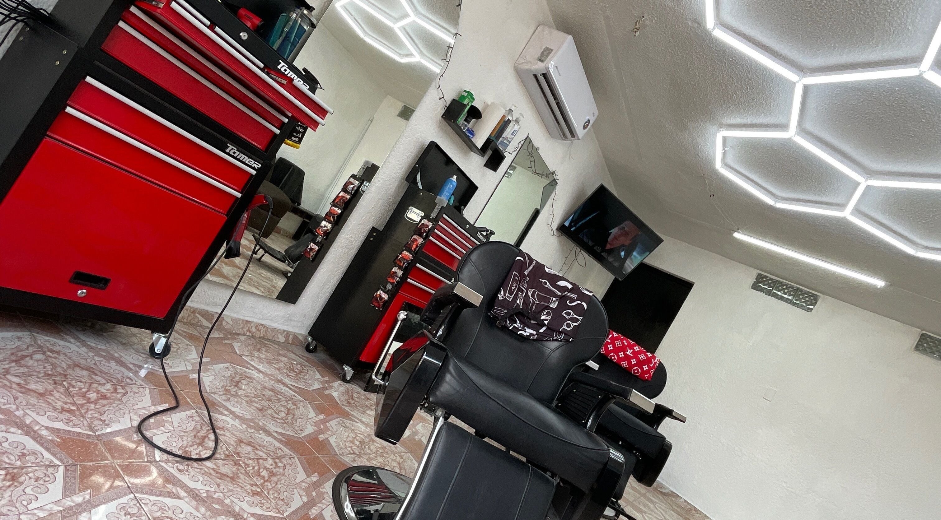 Interior de La Navaja Negra Barberia en Kanasín, Yucatán, MX. Silla negra y decoración moderna.