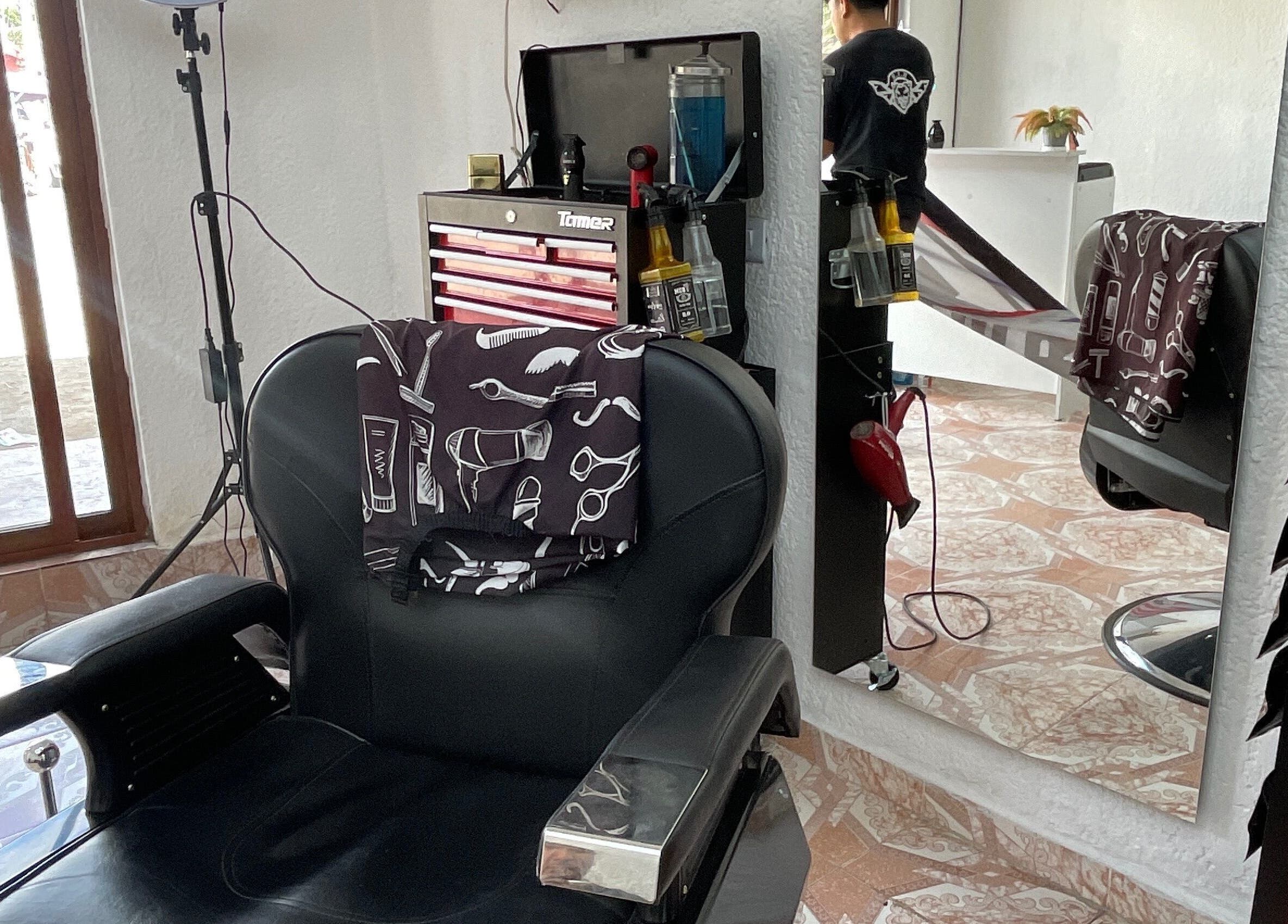 Silla de barbero en La Navaja Negra Barberia, Kanasín, Yucatán, MX, reflejada en un espejo.