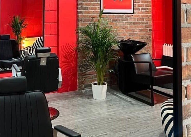 Stylish salon interior at Cult.Collective, Bristol, England, GB with red walls and modern black chairs.