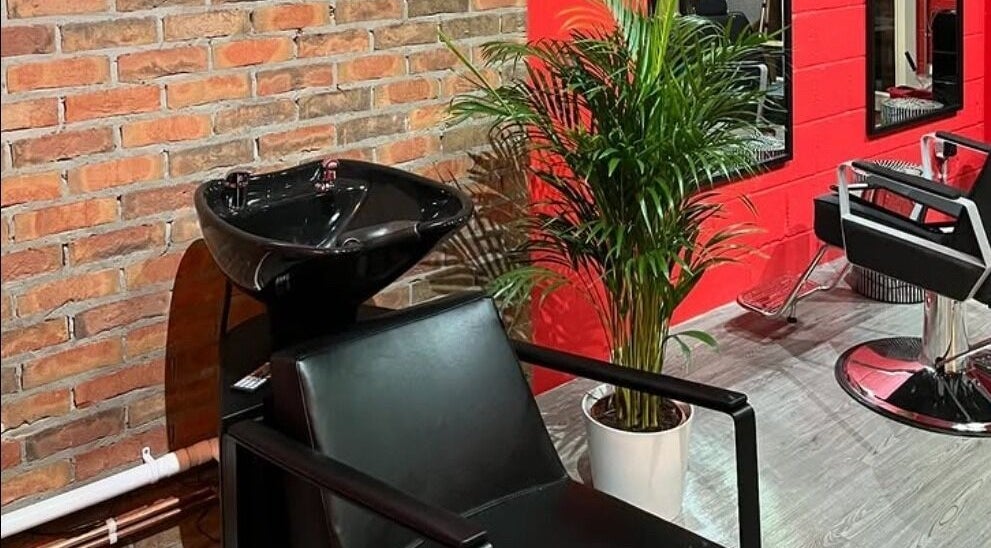 Modern salon interior at Cult.Collective in Bristol, England, GB with sleek chairs, plants, and vibrant decor.