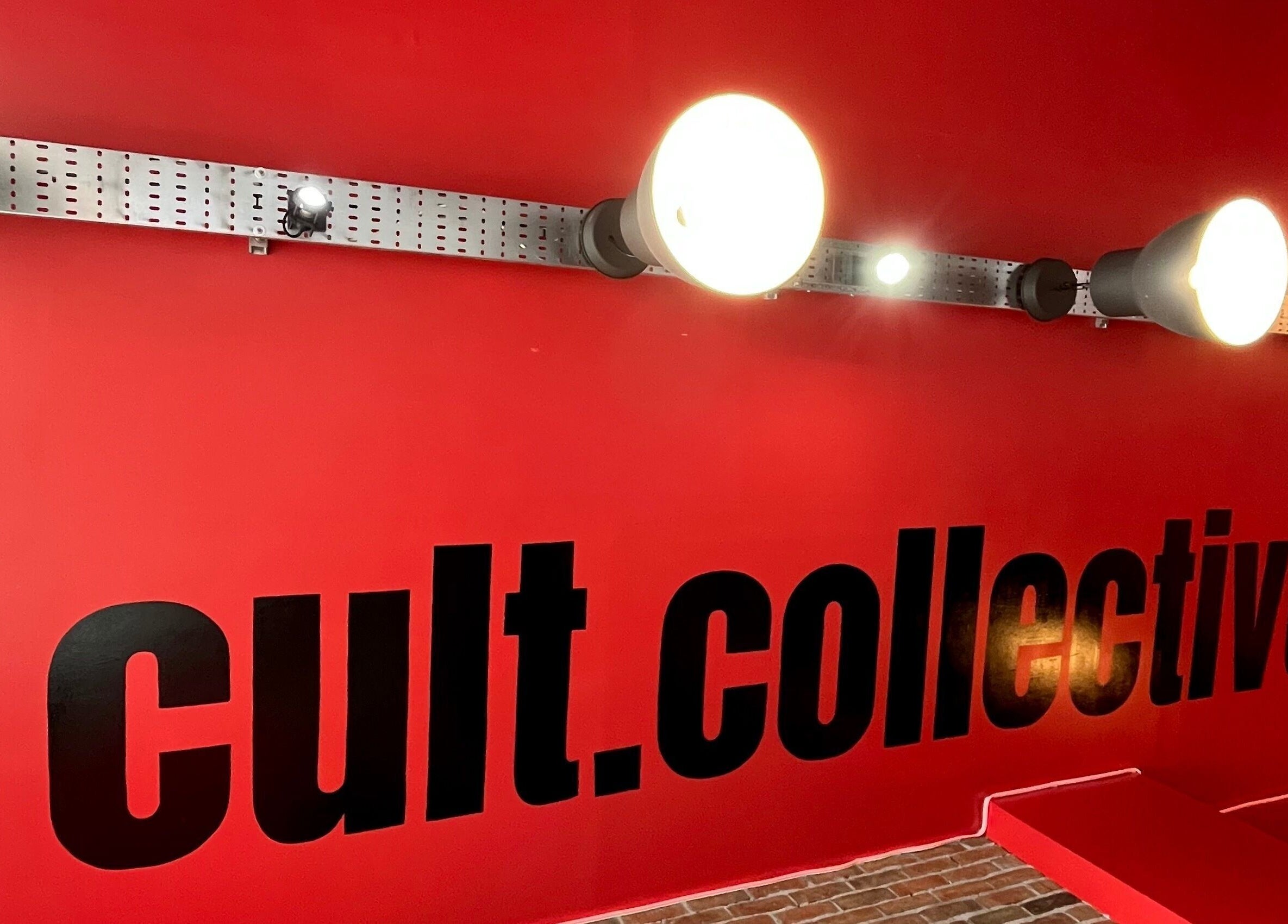 Cult.Collective entrance with vibrant red wall and bold black lettering in Bristol, England, GB.