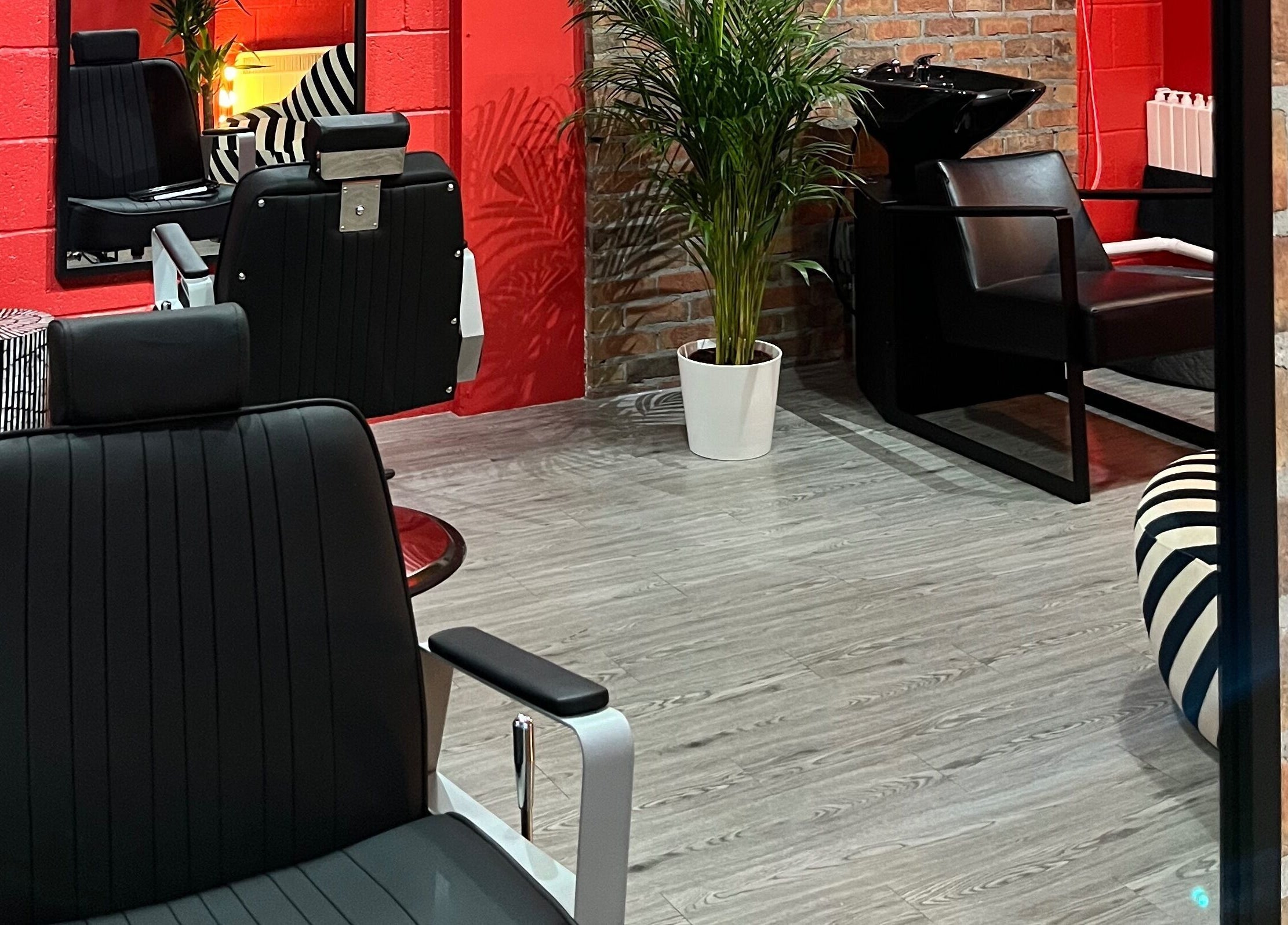 Modern salon setup at Cult.Collective, Bristol, England, GB with chic chairs and vibrant red accents.