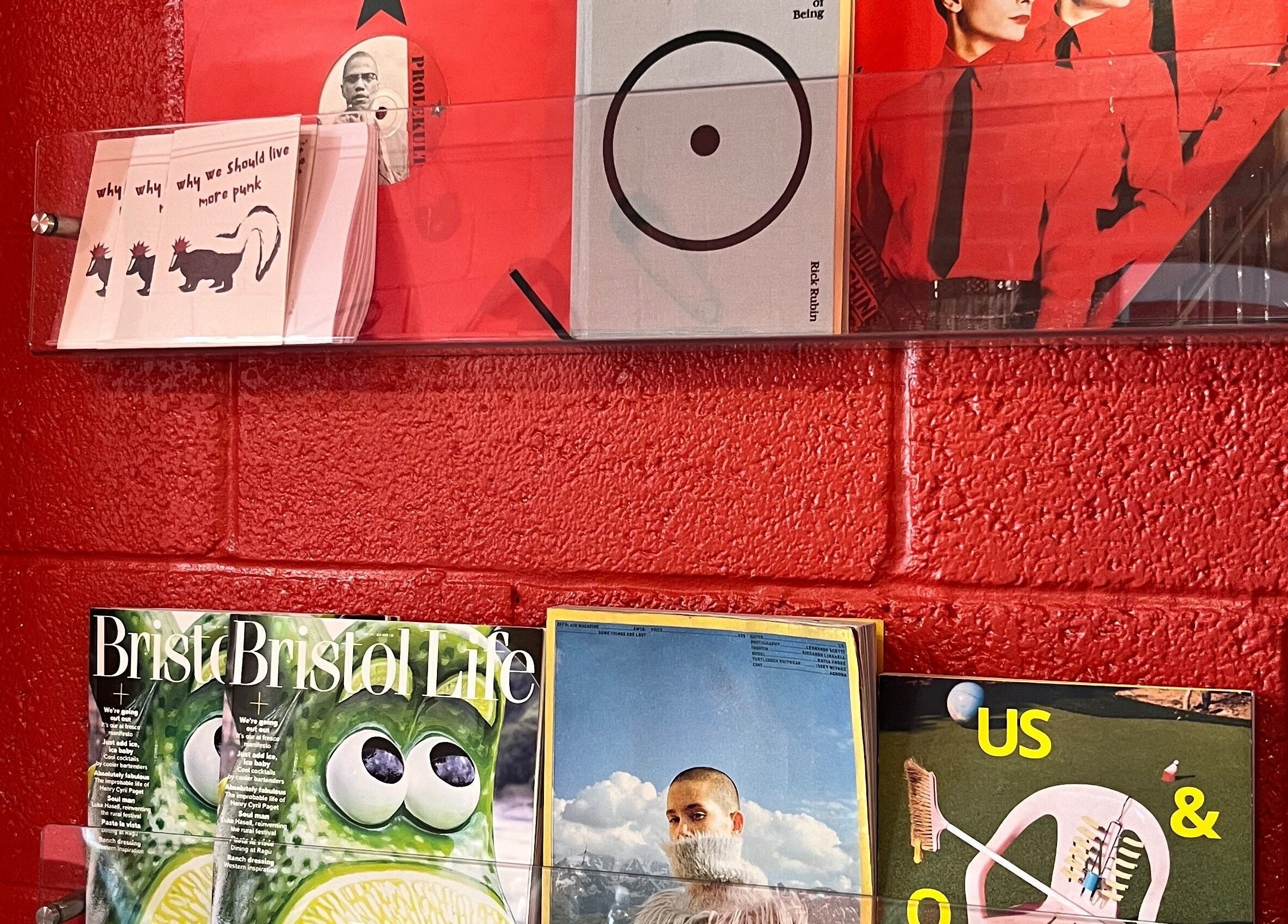Magazine and book display on a vivid red wall at Cult.Collective, Bristol, England, GB.