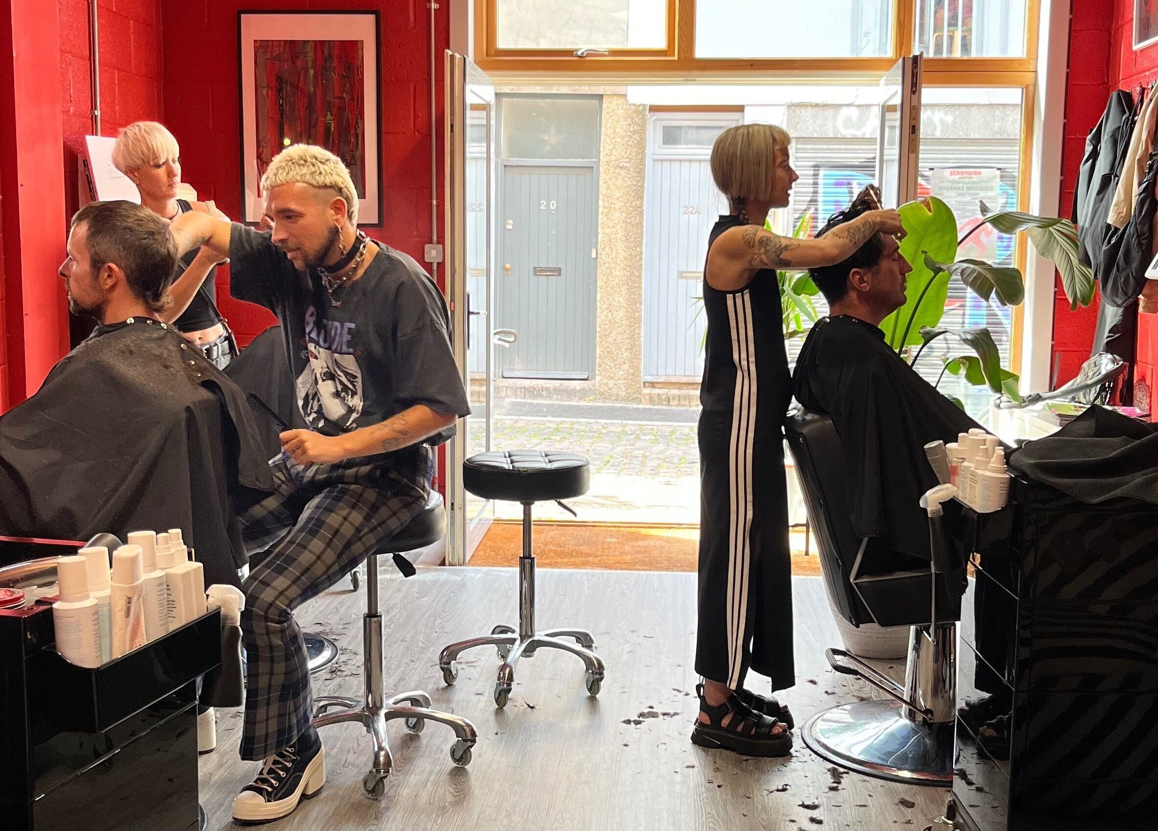Stylists at Cult.Collective in Bristol, England, GB, expertly cutting hair in a vibrant salon setting.