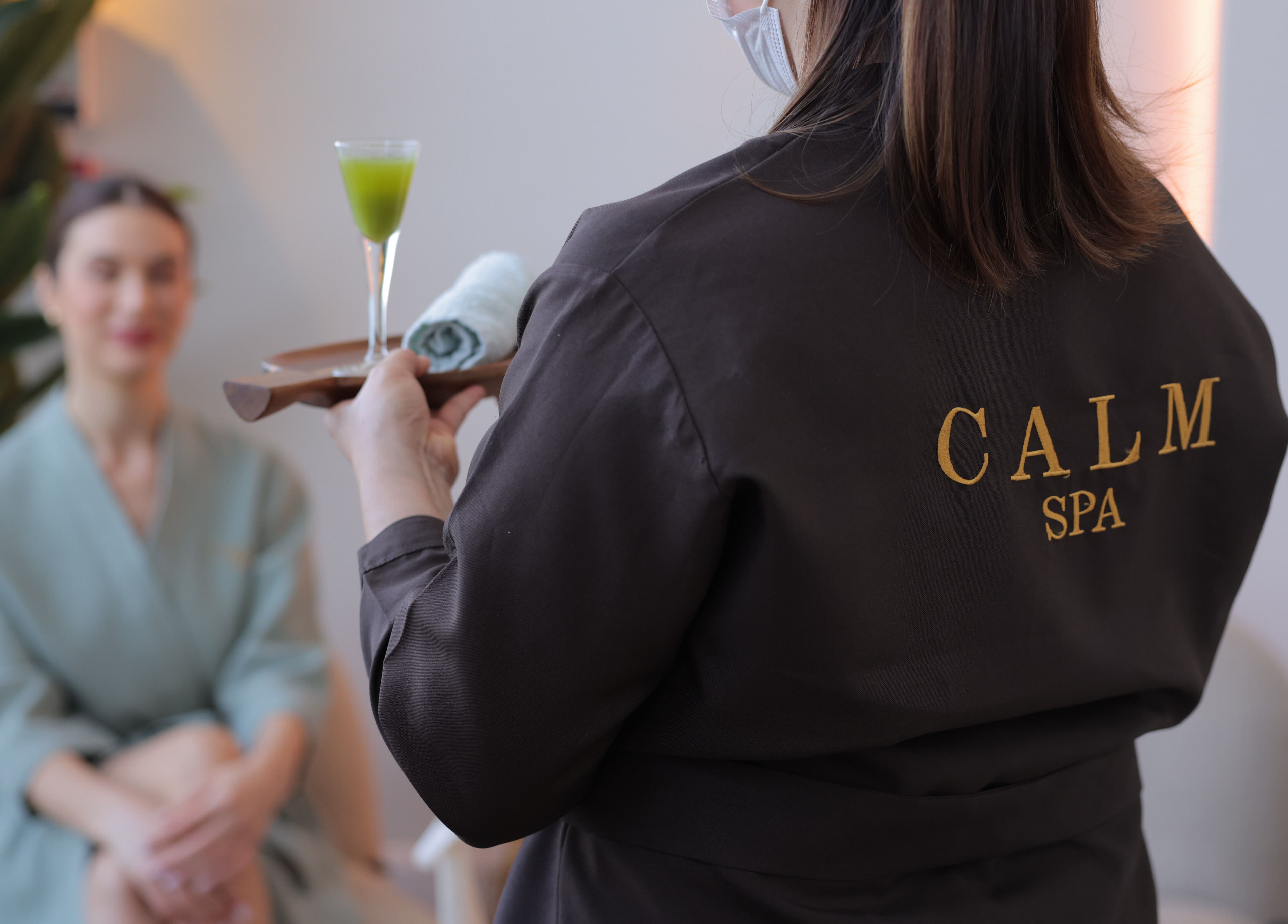 Calm Spa staff offering a refreshing drink to a customer, Riyadh, Riyadh Province, SA.
