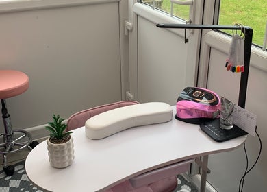Elegant nail station at Nailsbysadie in Merthyr Tydfil, Wales, GB with pink decor and manicure tools.