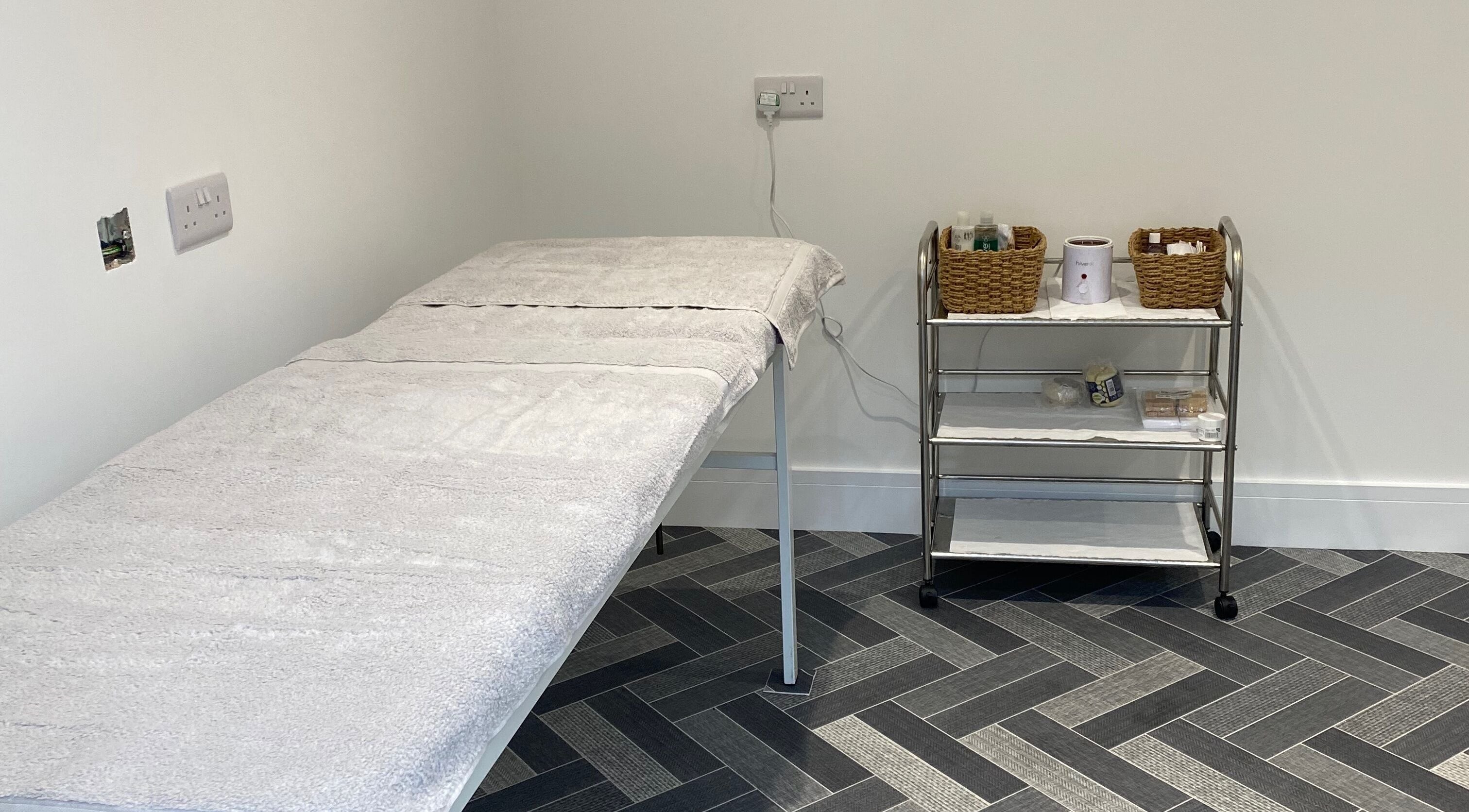 Calming treatment room at Nailsbysadie, Merthyr Tydfil, Wales, GB with massage table and essentials.