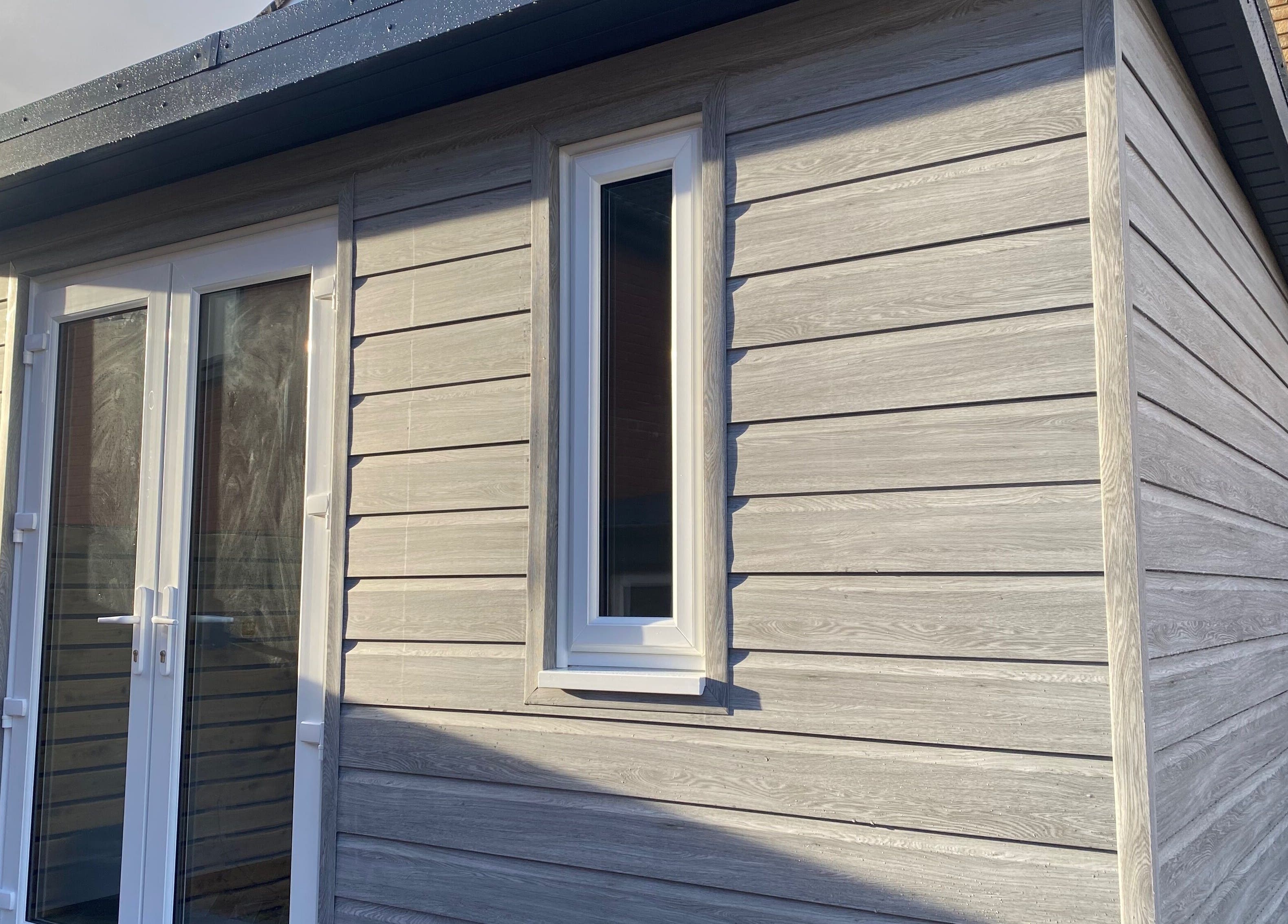 Exterior of Nailsbysadie, a stylish wooden venue in Merthyr Tydfil, Wales, GB, with modern white doors.