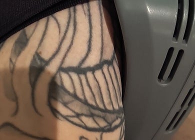 Close-up of a tattooed arm receiving a therapy treatment at Elevation Body Boost, Vancouver, British Columbia, CA.