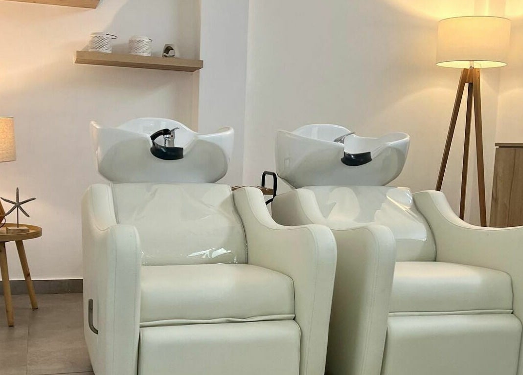 Área de lavado en La Femme del Sur, Lima, Lima, PE, con sillas blancas y decoración acogedora.