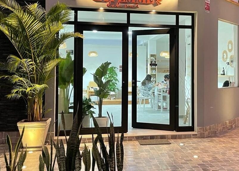 Entrada iluminada de La Femme del Sur en Lima, Lima, PE, mostrando plantas decorativas y diseño acogedor.