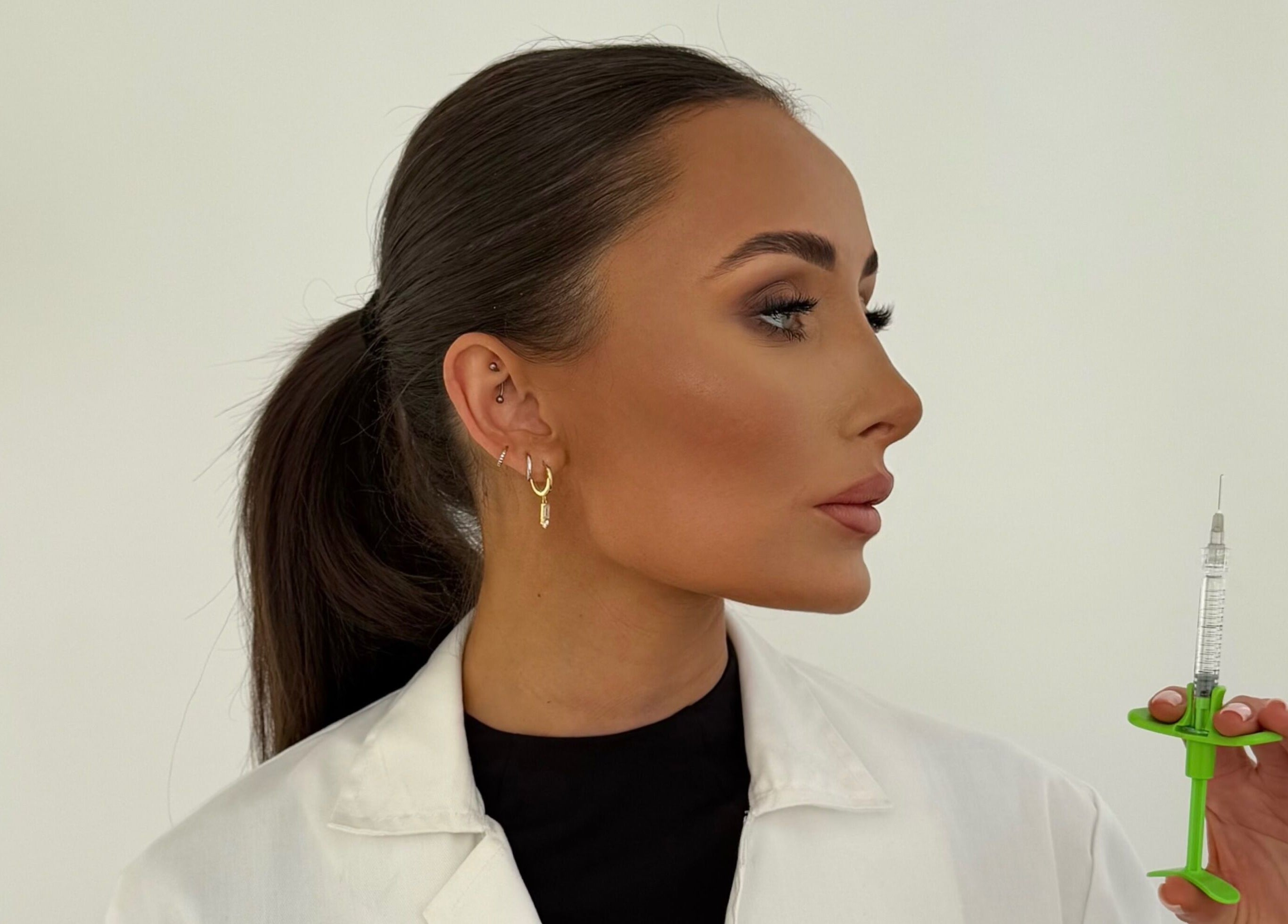 Professional holding syringe at Reify Aesthetics in Chorley, England, GB for beauty treatments.