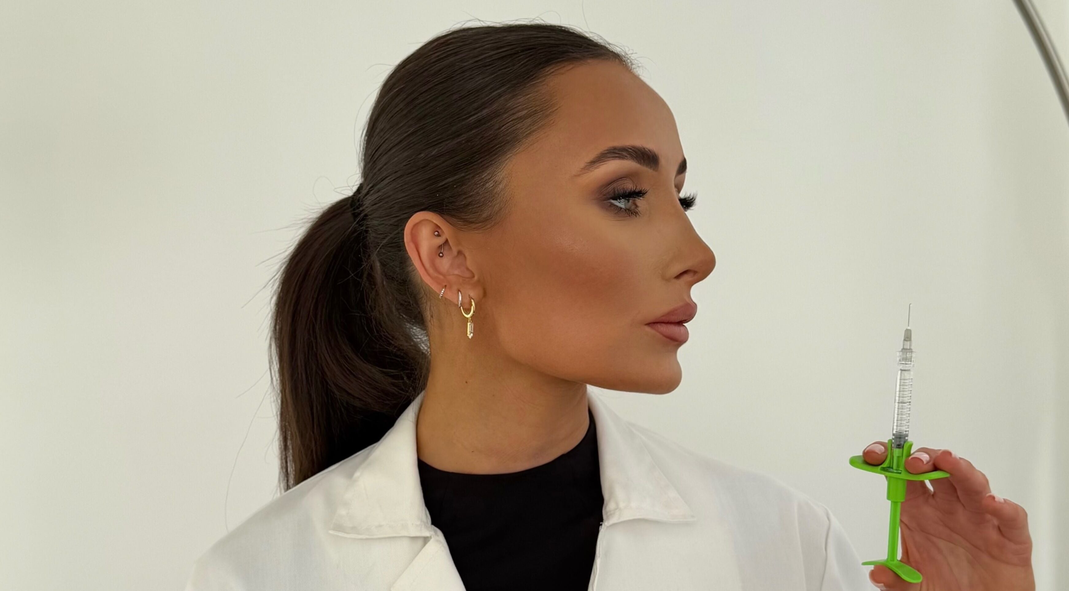 Professional holding syringe at Reify Aesthetics in Chorley, England, GB for beauty treatments.