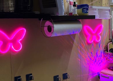 Pink neon butterfly lights at Tru Skin Studio, Lucea, Hanover Parish, JM create a vibrant, welcoming atmosphere.