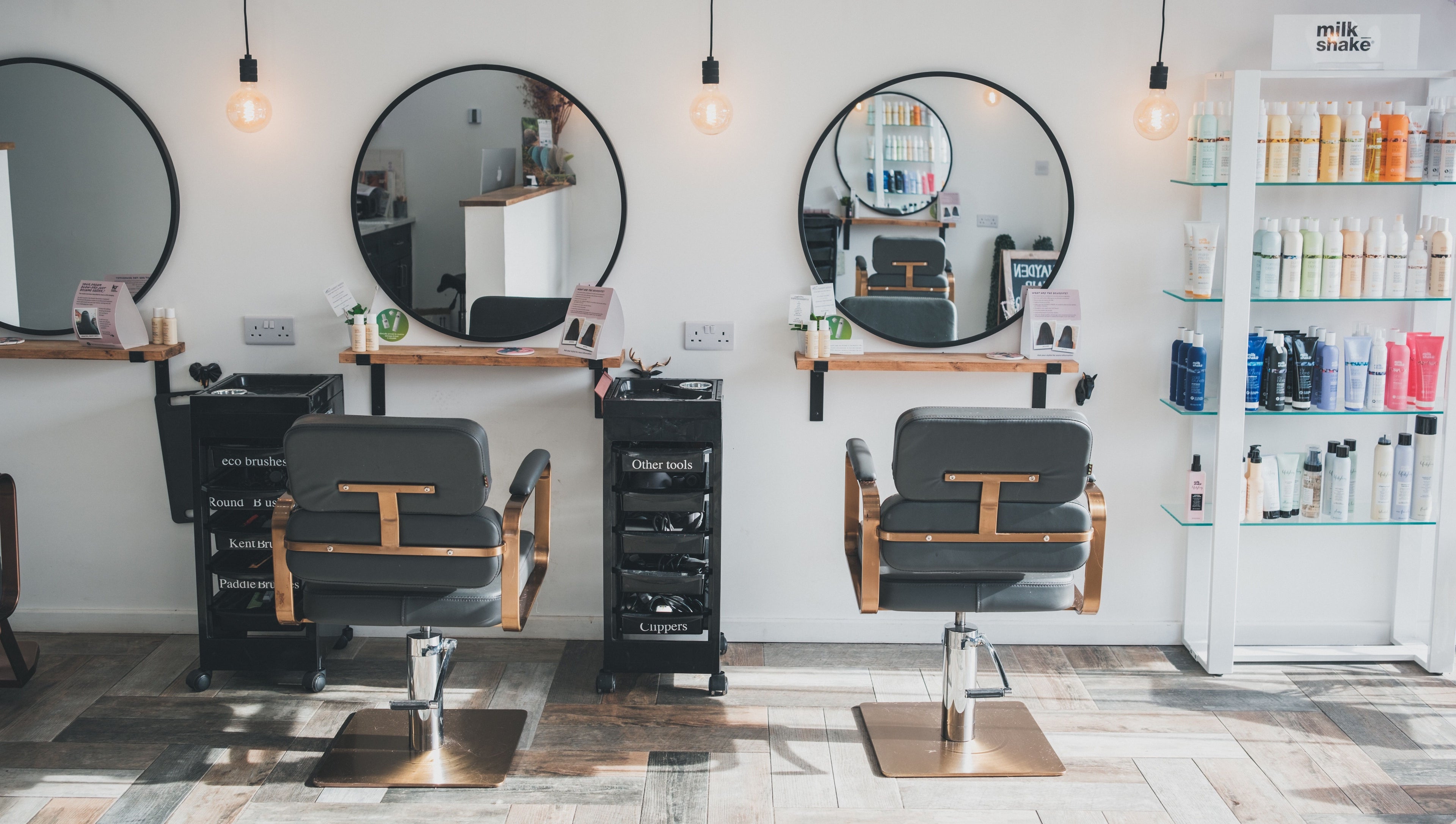 Interior of Hayden Hair Studio in Bletchley, England, GB with styling chairs and product shelves.