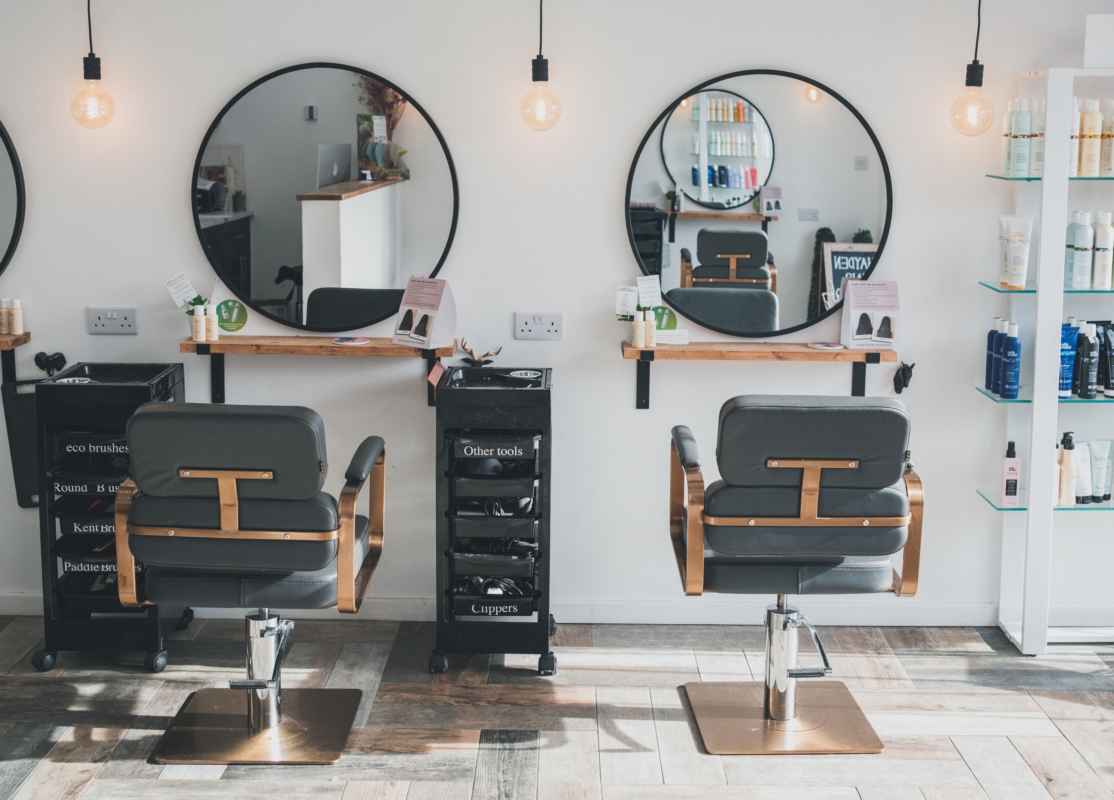 Interior of Hayden Hair Studio in Bletchley, England, GB with styling chairs and product shelves.