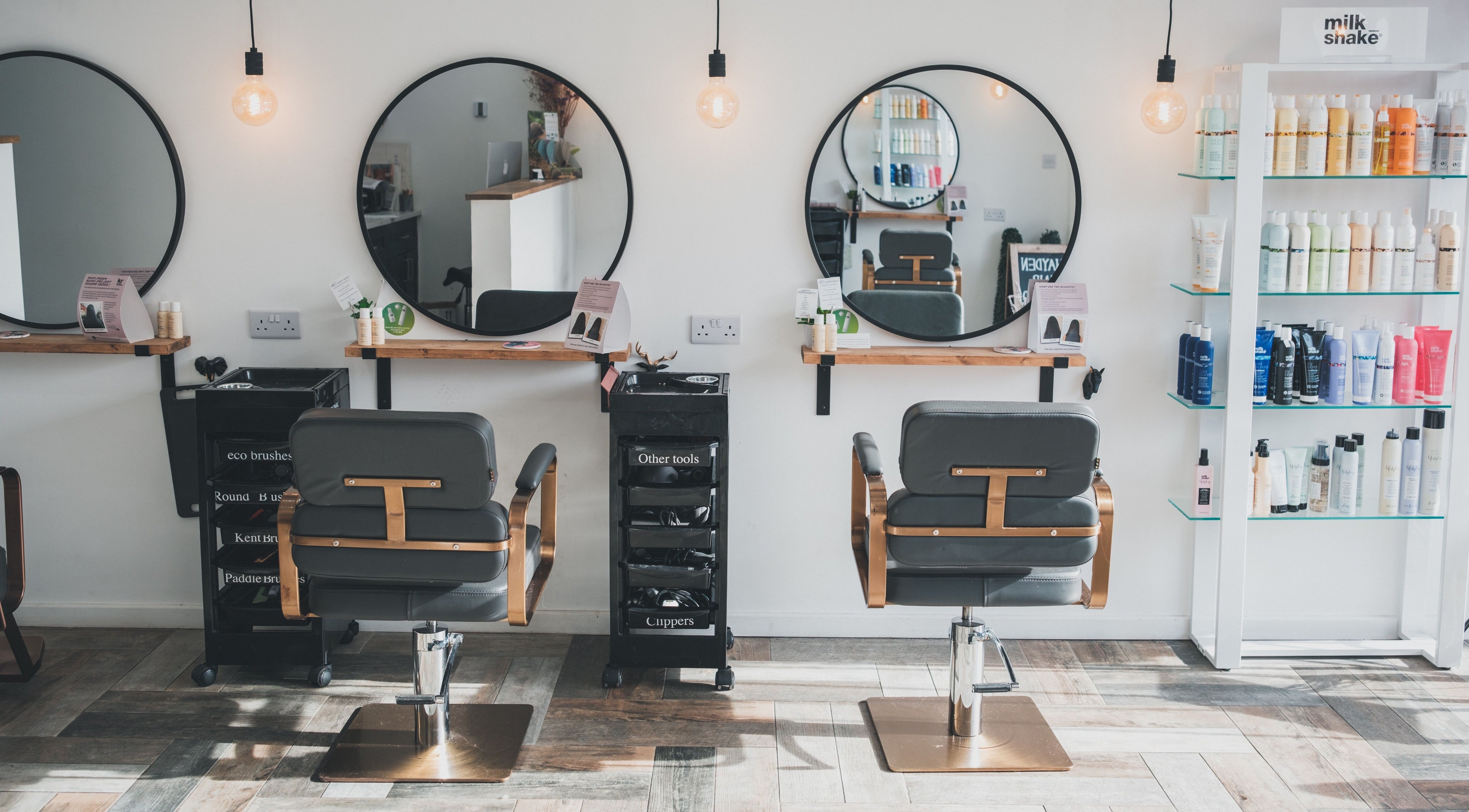 Interior of Hayden Hair Studio in Bletchley, England, GB with styling chairs and product shelves.