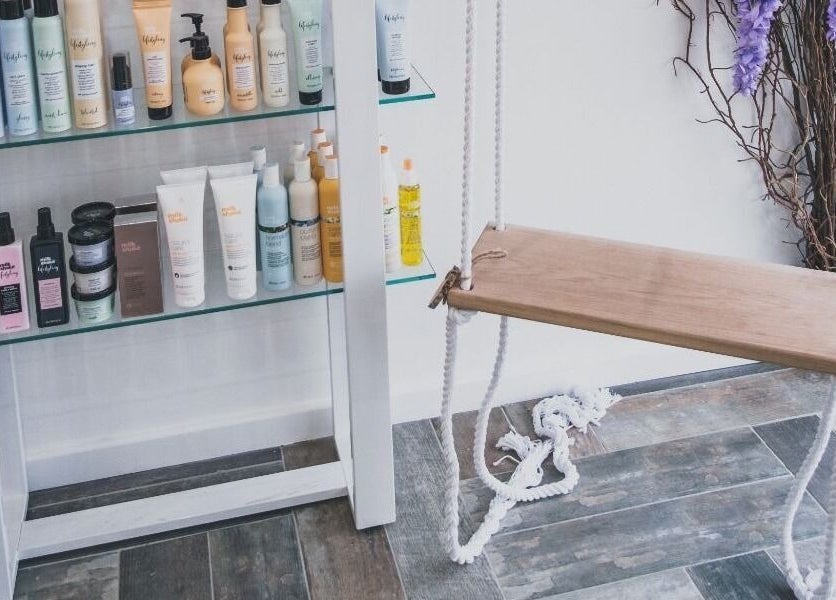 Hayden Hair Studio in Bletchley, England, GB, features elegant product displays and a chic wooden swing.