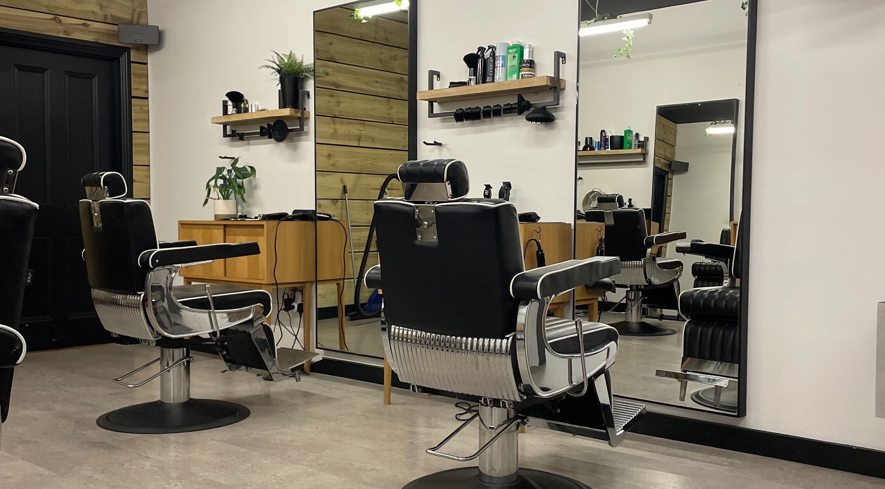 Stylish interior of One Four Barbershop in Newbridge, County Kildare, IE featuring sleek black barber chairs.