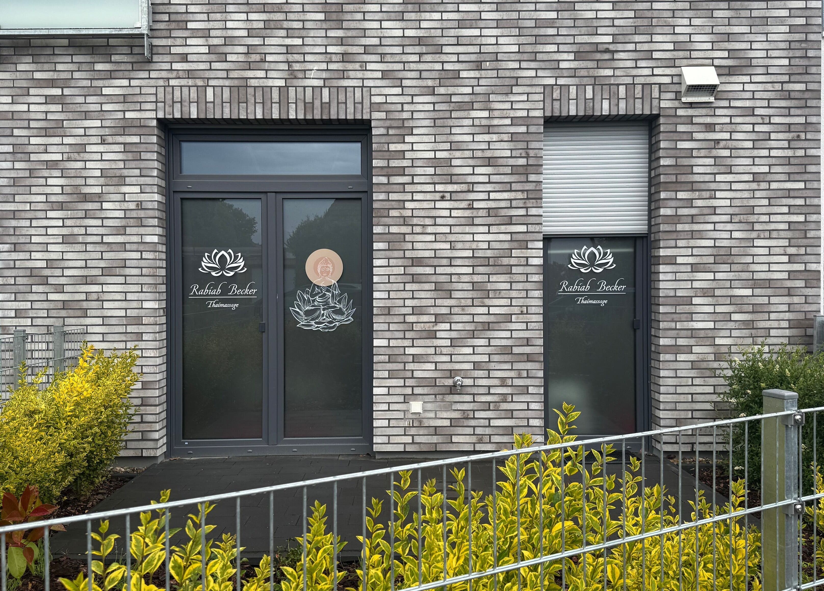 Eingang zu Rabiab-Becker-Thaimassage in Braunschweig, Niedersachsen, DE, umgeben von grünen Pflanzen.