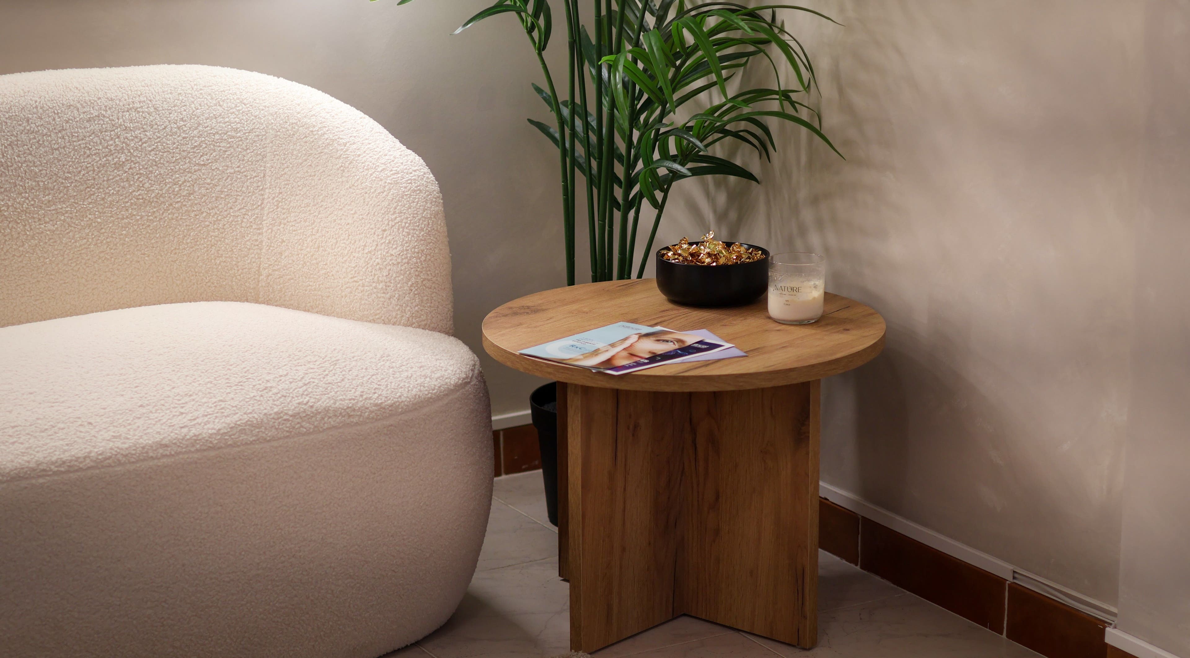 Área relaxante no Liliana Louro Beauty, Barreiro, Setúbal, PT, com poltrona, mesa de madeira e planta.