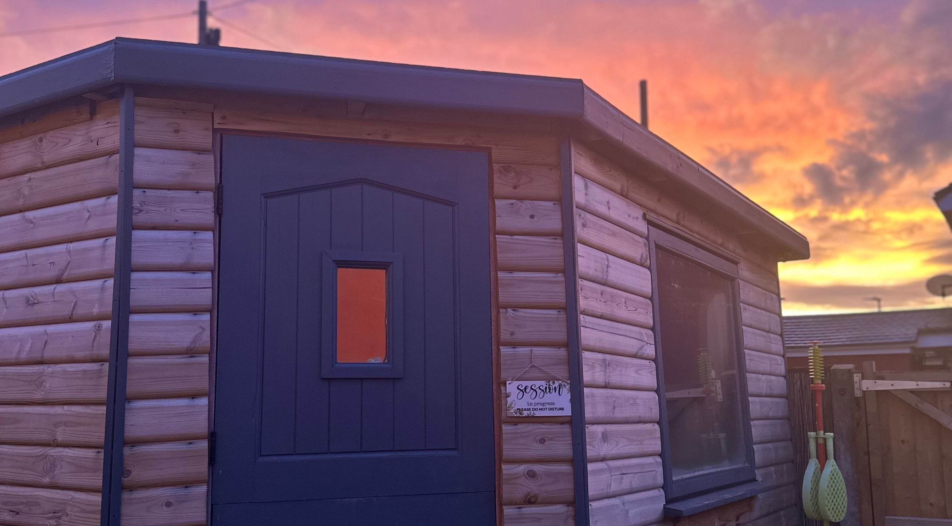 Cozy wooden cabin at Eunoia holistic beauty in Hull, England, GB during a stunning sunset.