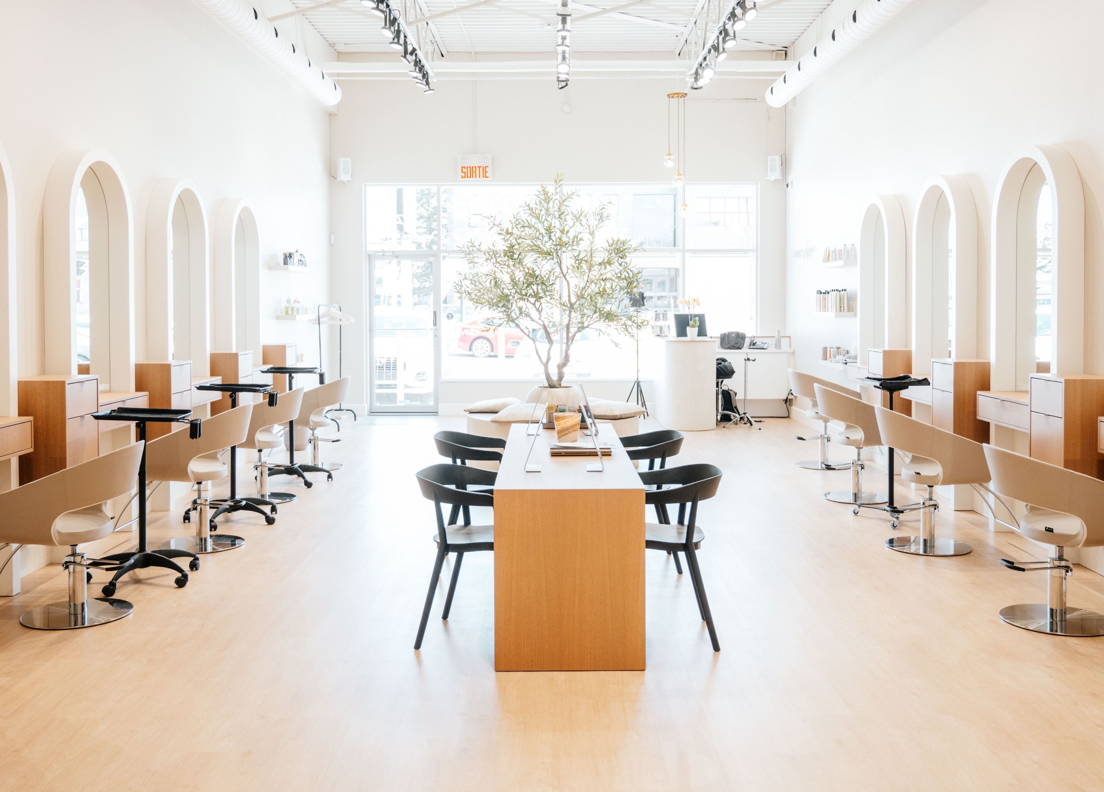 Modern interior of Salon Goldn in Laval, Québec, CA with chic styling stations and natural lighting.