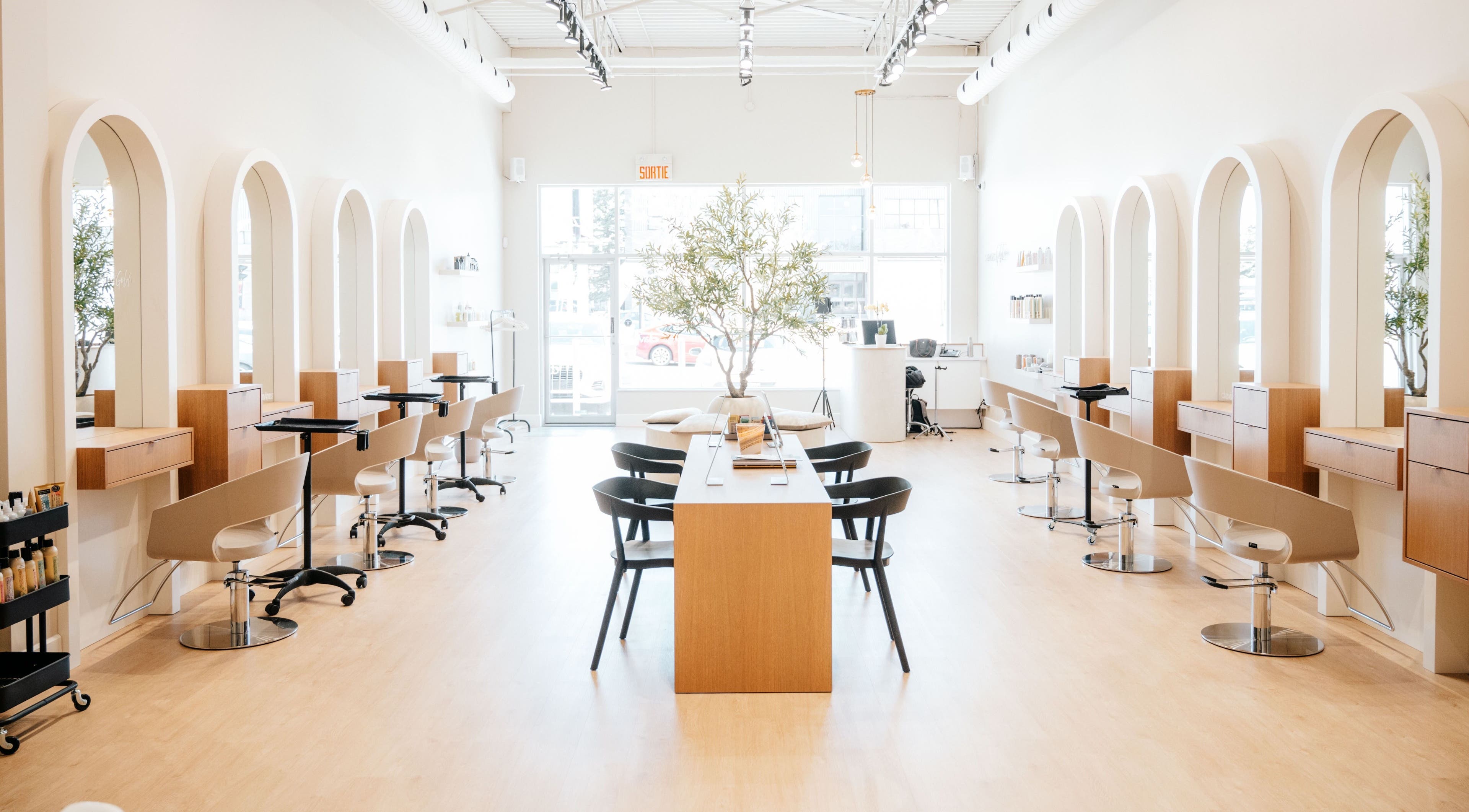 Modern interior of Salon Goldn in Laval, Québec, CA with chic styling stations and natural lighting.