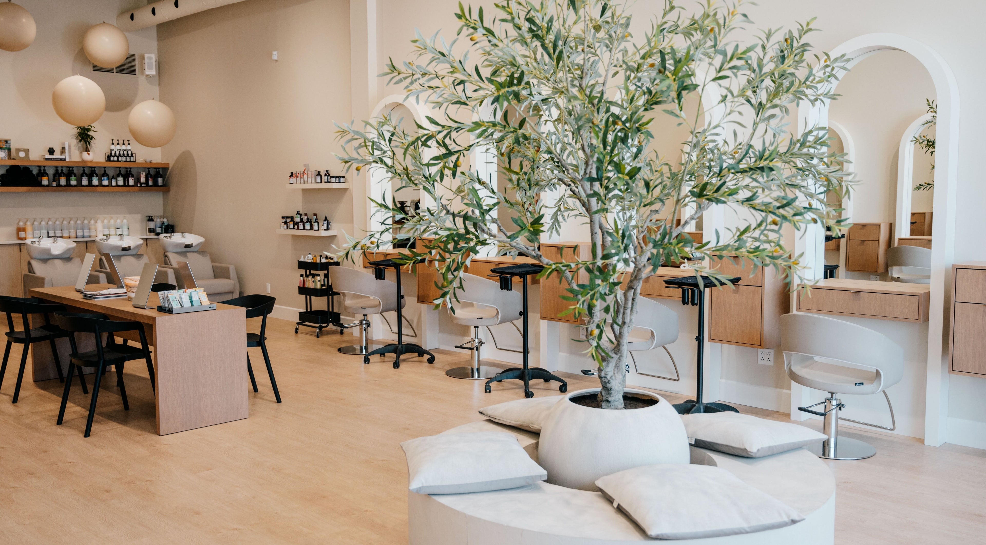 Elegant interior of Salon Goldn in Laval, Québec, CA, featuring modern chairs and a stylish tree centerpiece.