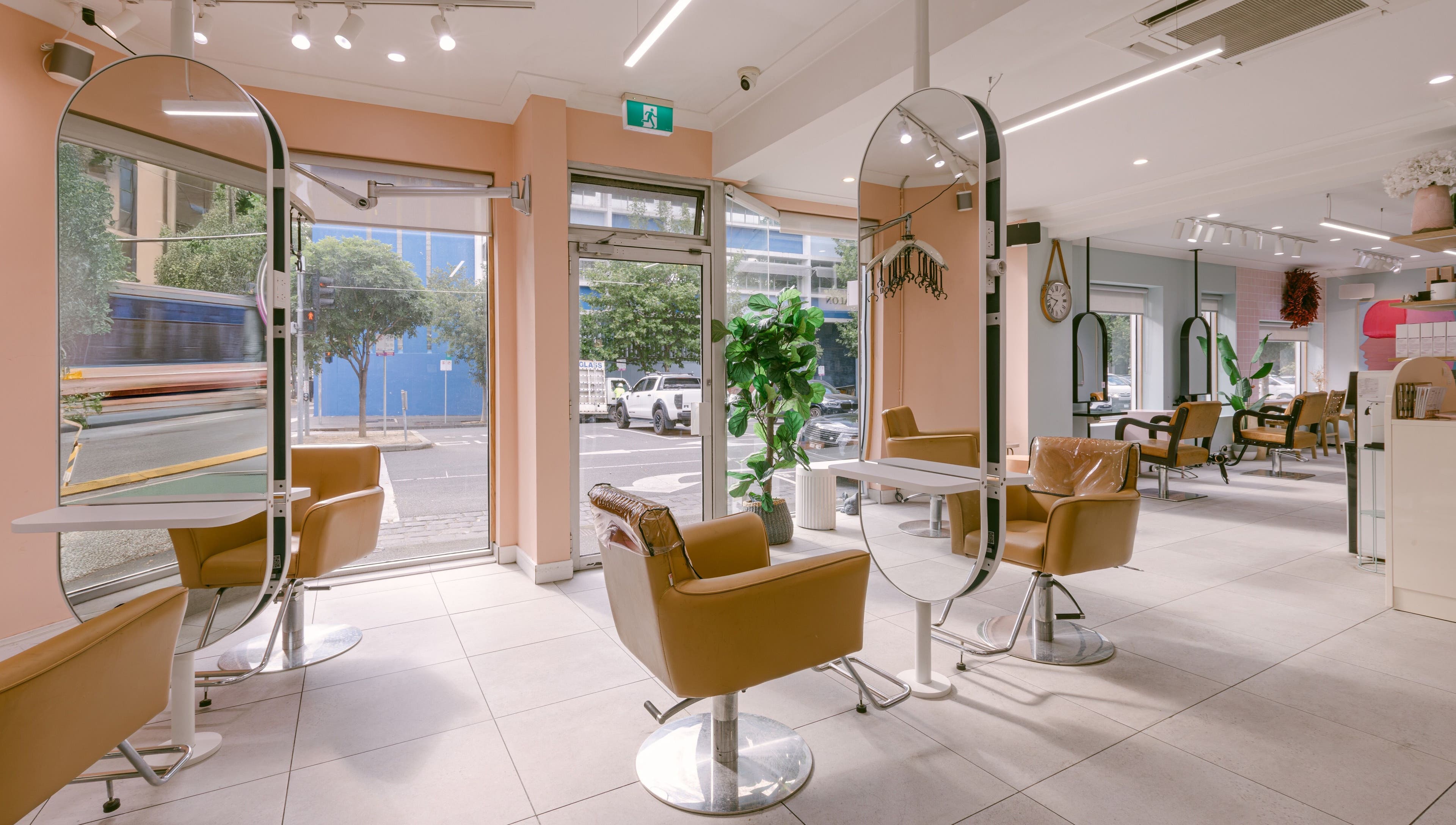 Modern interior of Le Ciel Salon in Carlton, Victoria, AU with stylish chairs and mirrors.