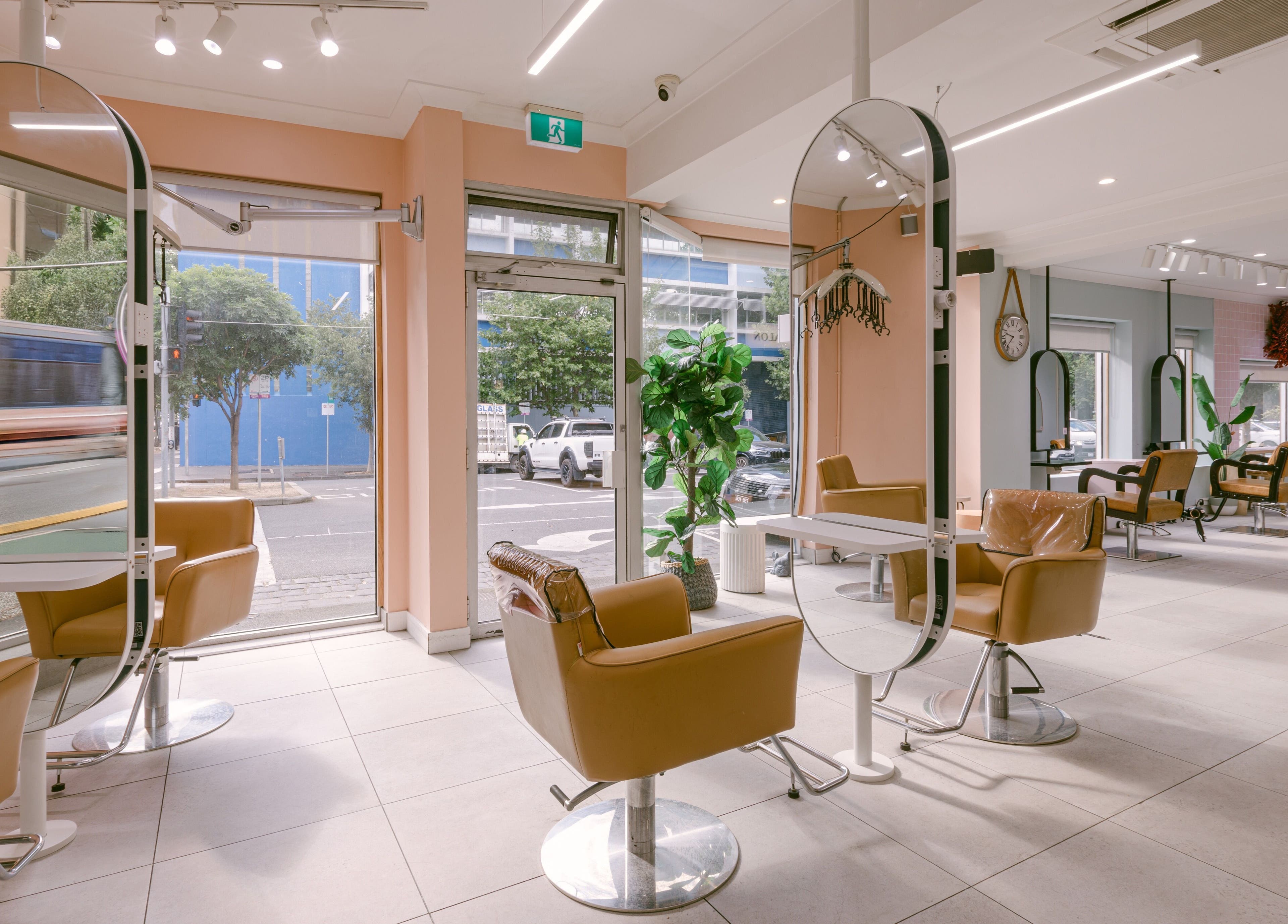 Modern interior of Le Ciel Salon in Carlton, Victoria, AU with stylish chairs and mirrors.