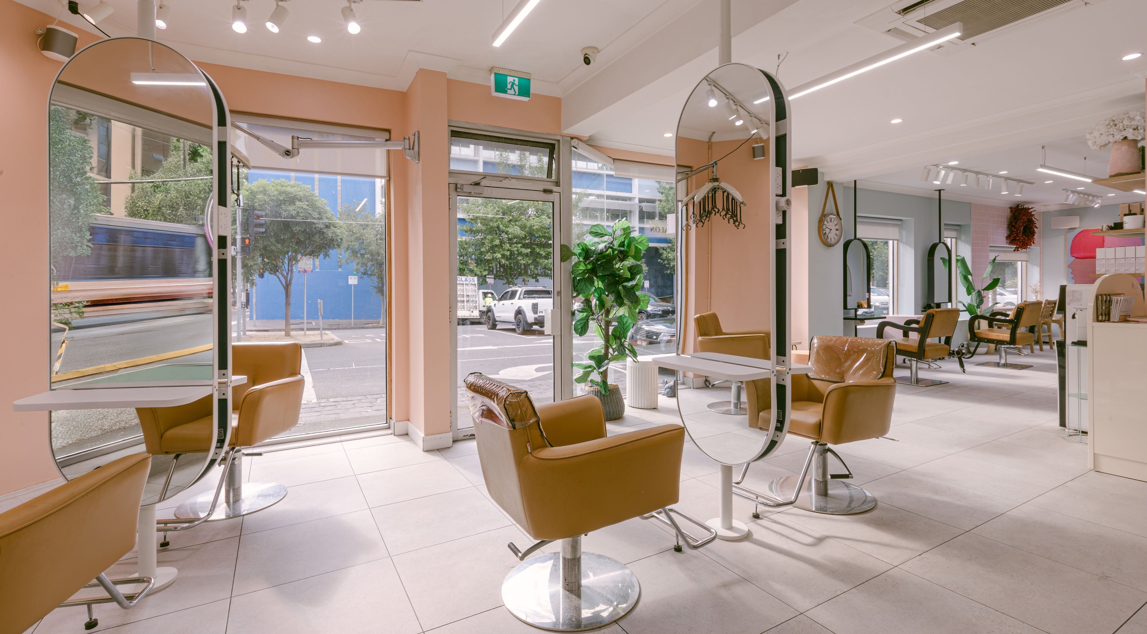 Modern interior of Le Ciel Salon in Carlton, Victoria, AU with stylish chairs and mirrors.