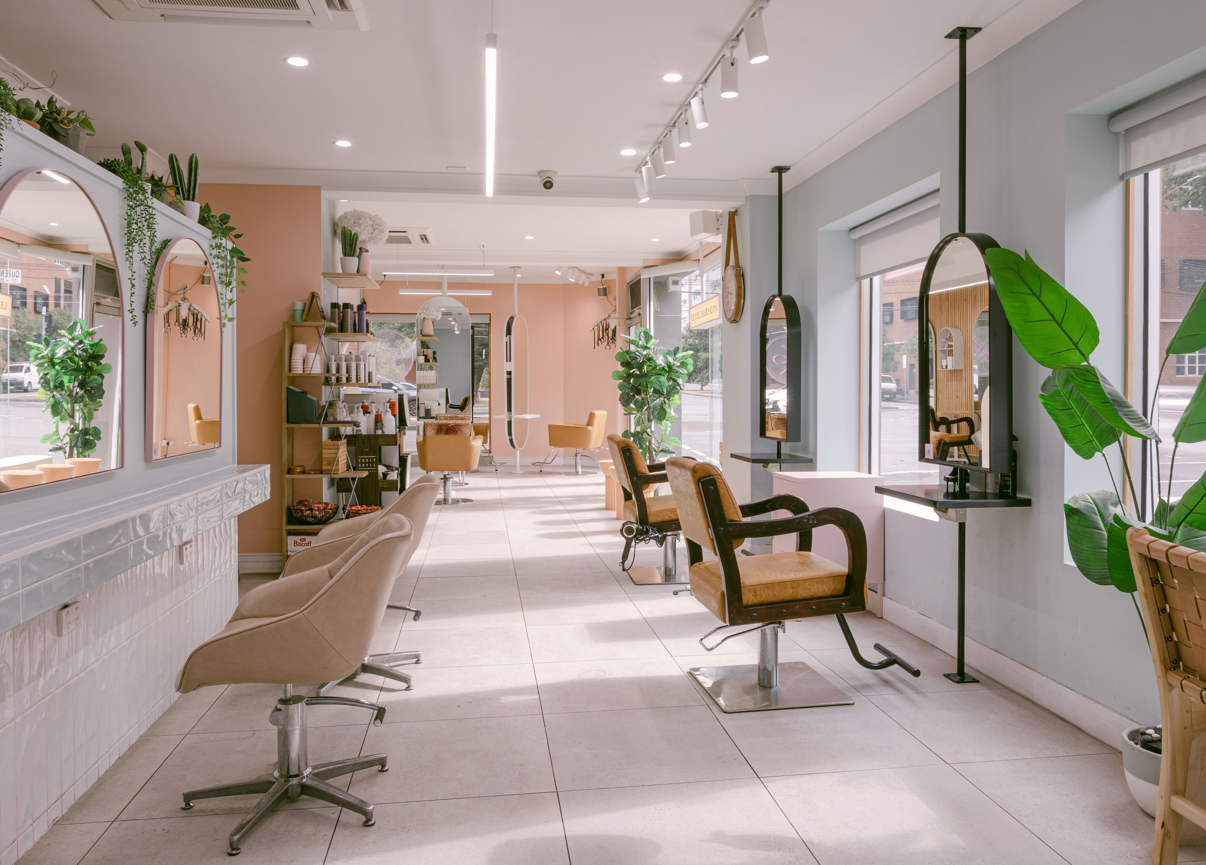 Elegant interior of Le Ciel Salon in Carlton, Victoria, AU with stylish chairs and lush greenery.