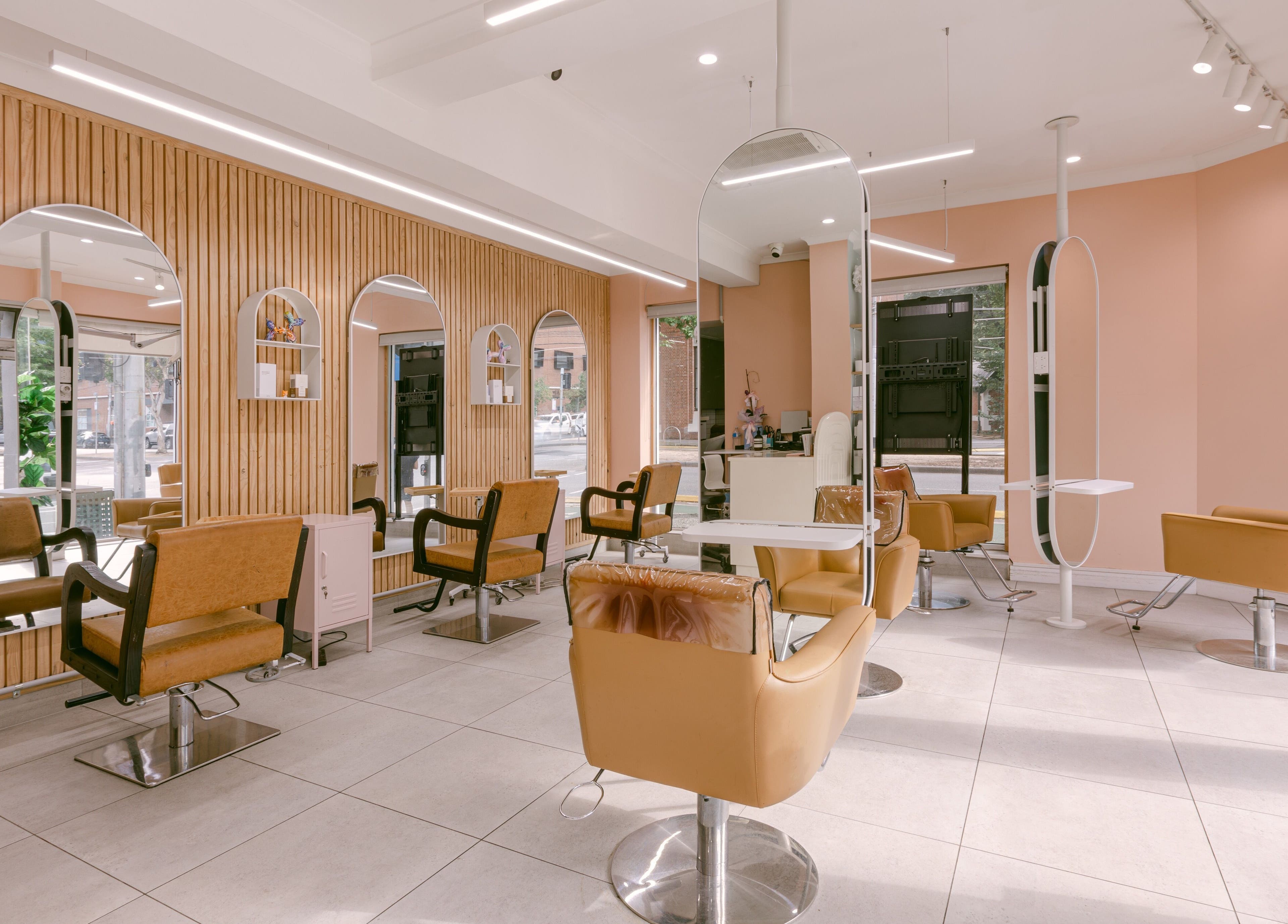 Trendy and modern interior of Le Ciel Salon in Carlton, Victoria, AU with stylish chairs and mirrors.