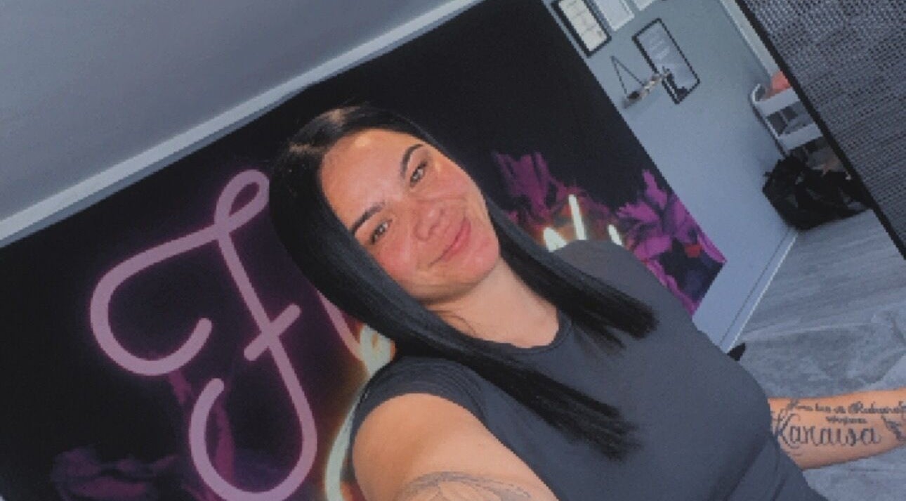 Smiling person at Fivewax venue, Auckland, Auckland, NZ. Vibrant wall art in background.