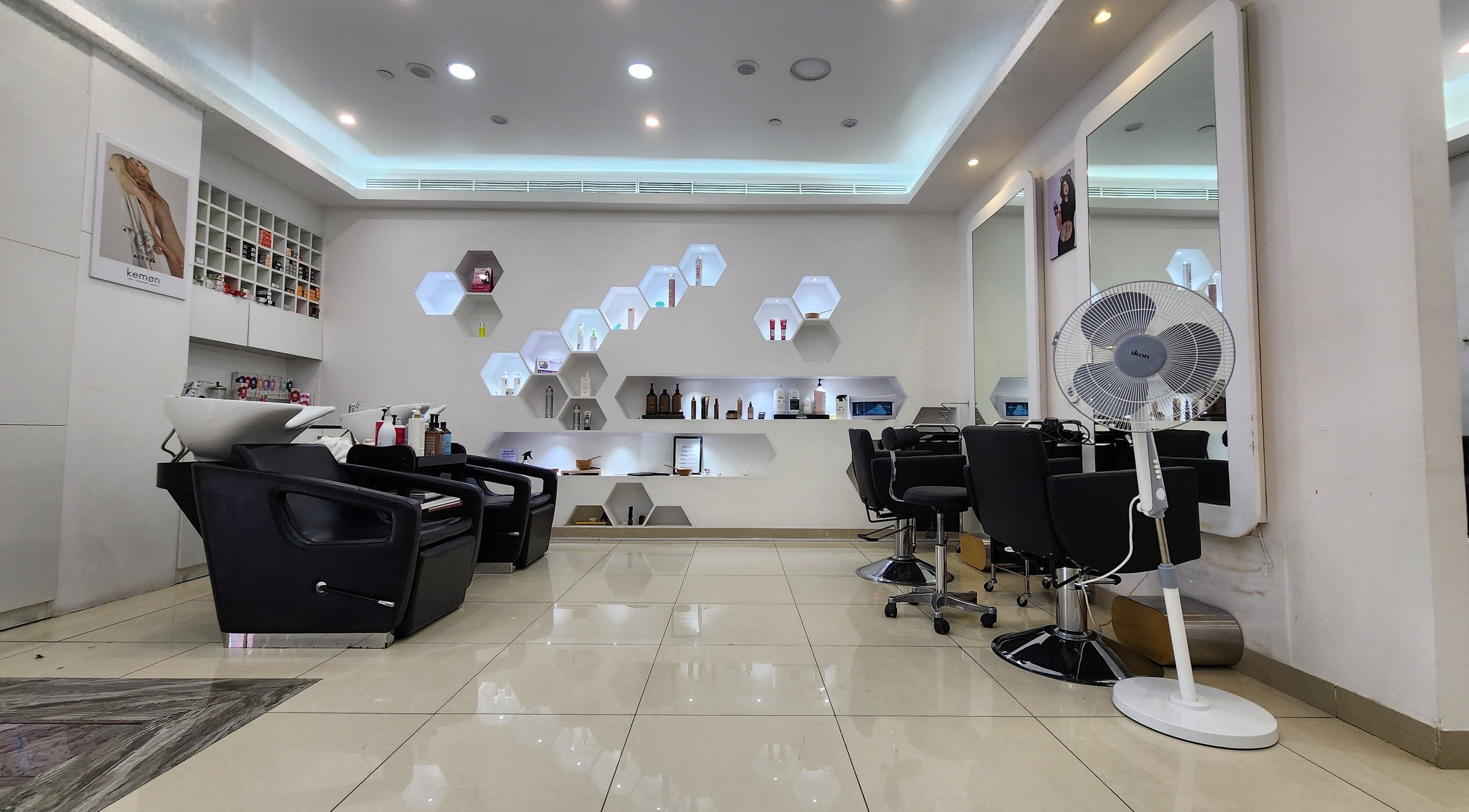 Modern salon interior at Cut and Colours Beauty Center, Abu Dhabi, featuring sleek chairs and stylish decor.