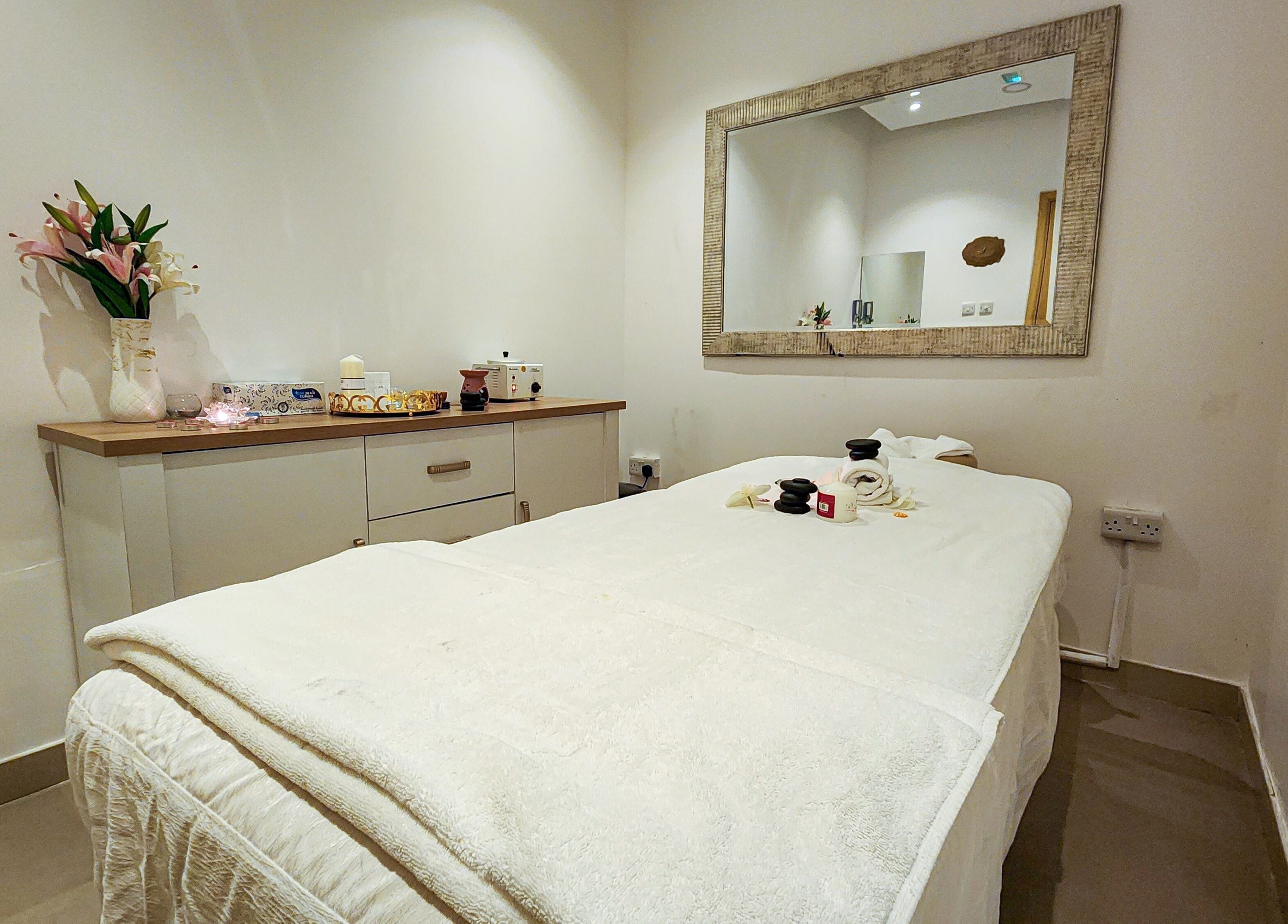 Relaxing spa room at Cut and Colours Beauty Center, Abu Dhabi, AE, featuring a massage table and calming decor.
