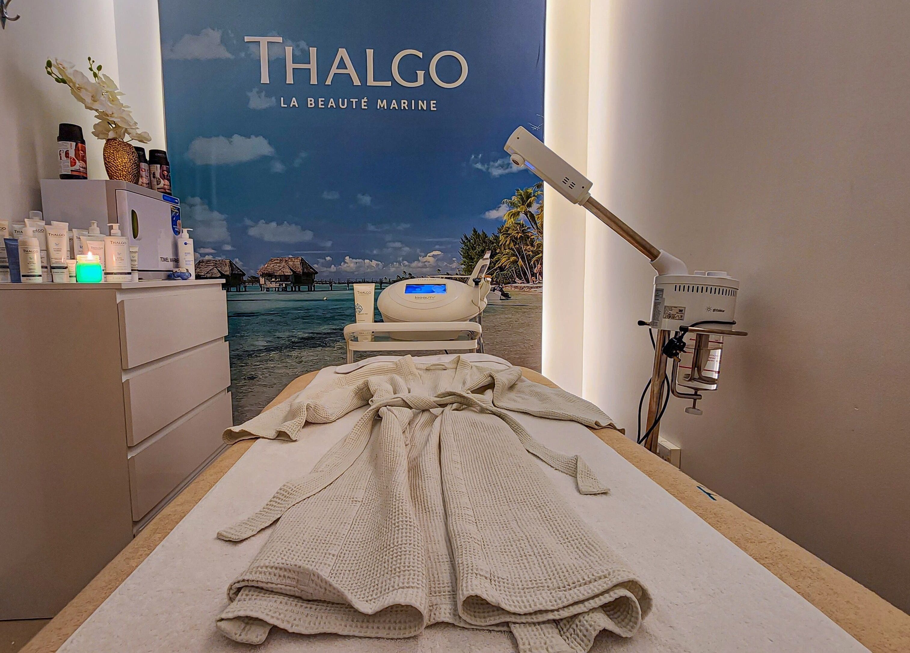 Relaxing spa room at Cut and Colours Beauty Center in Abu Dhabi, AE, featuring Thalgo products and treatment bed.
