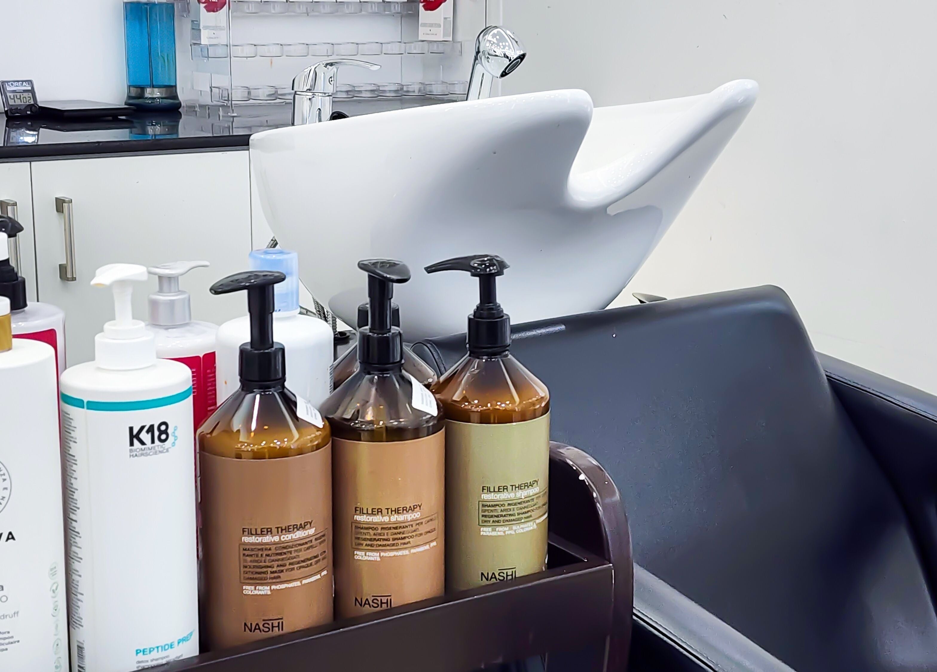 Shampoo and conditioner at Cut and Colours Beauty Center in Abu Dhabi, Abu Dhabi, AE, featuring a sleek washing station.