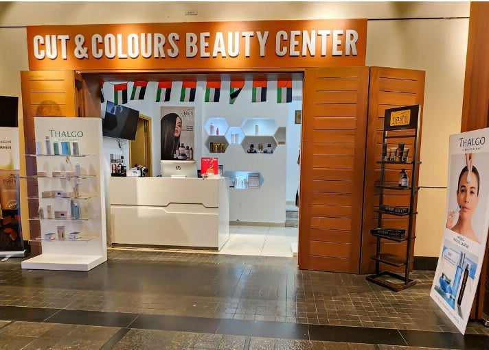Entrance of Cut and Colours Beauty Center showcasing product displays in Abu Dhabi, Abu Dhabi, AE.