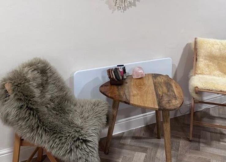 Cozy seating area at Natural Therapies with Kelly Aston, Gnosall, England, GB, featuring plush chairs and a wooden table.