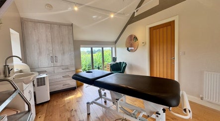 Relaxing treatment room at KK Clinic in Ashby-de-la-Zouch, England, GB with a massage table and modern decor.